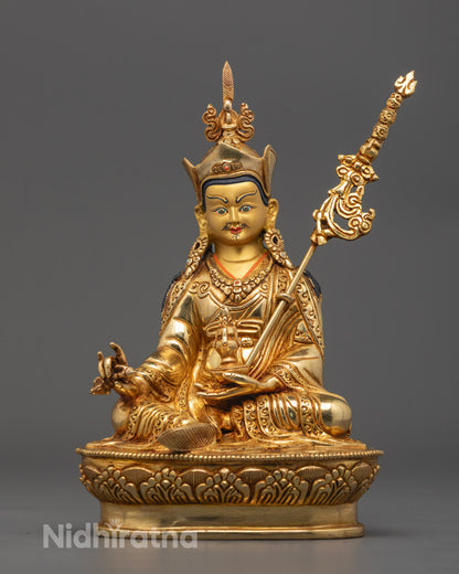 Hand-carved Guru Rinpoche statue in 24k gold gilded copper, showing intricate details and vibrant acrylic colors, crafted by Nepalese artisans using the lost wax method.