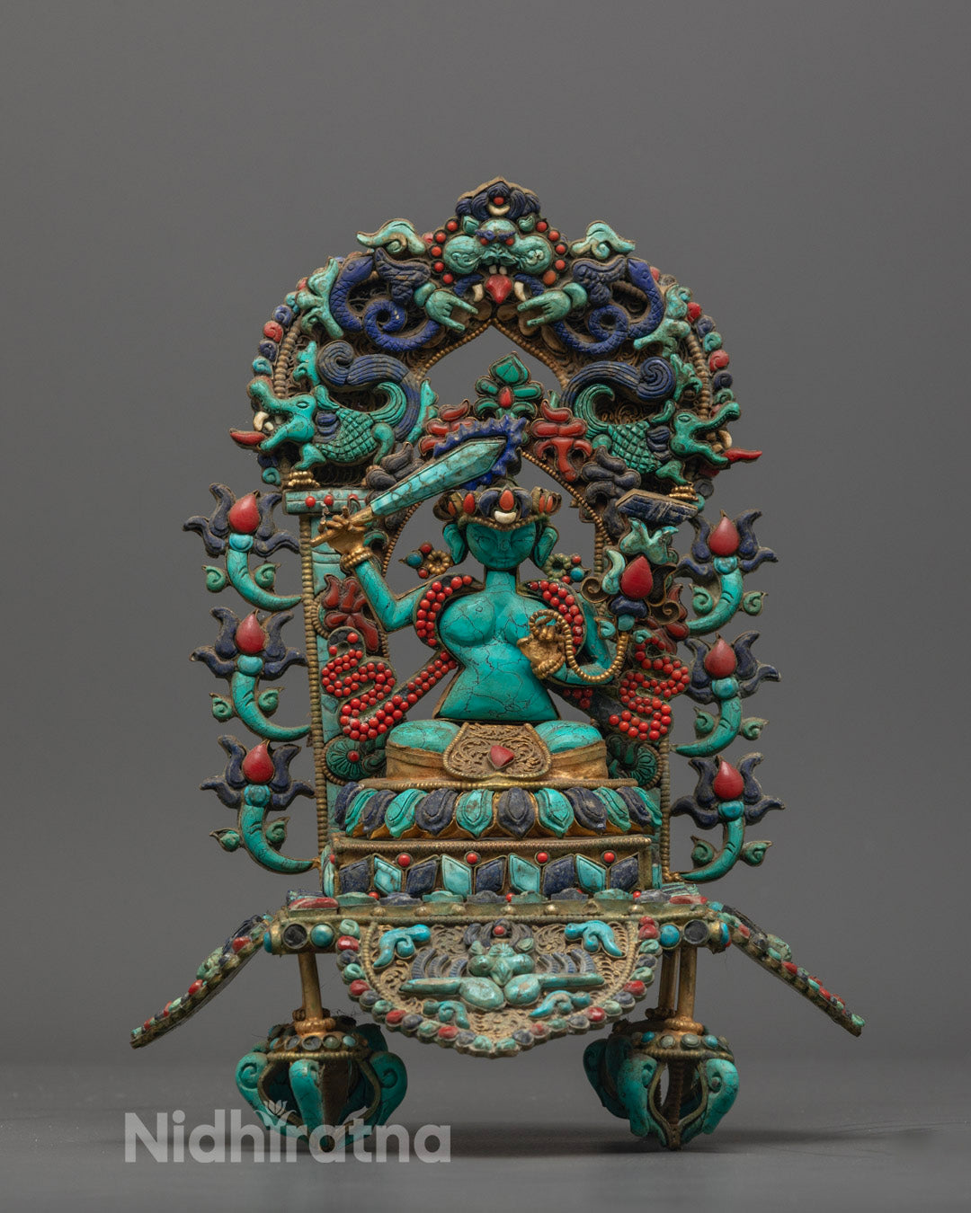 Hand-carved Manjushri statue holding flaming sword and lotus, crafted from precious stones and adorned with semi-precious gems.