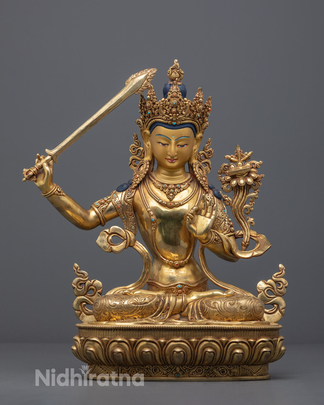 Hand-carved Manjushri statue in 24k gold gilded copper adorned with semi-precious stones, crafted by Nepali artisans.