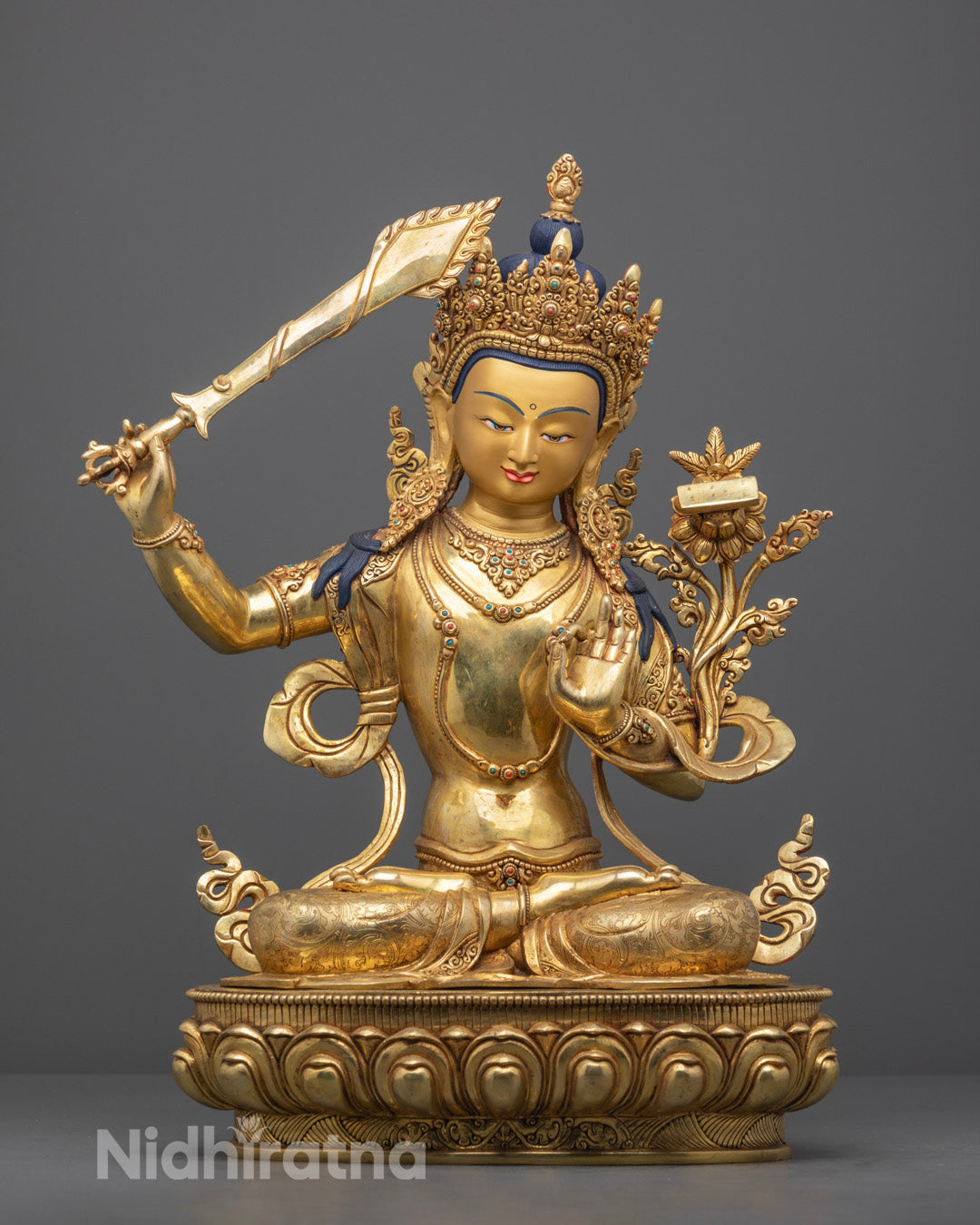 Hand-carved Manjushri statue seated on lotus throne with intricate 24k gold fire-gilded details.