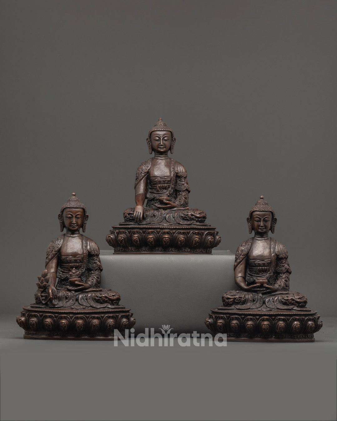 Hand-carved Three Buddha Statue Set made of oxidized copper, featuring intricate details and vibrant acrylic colors, crafted using the lost wax method in Nepal.