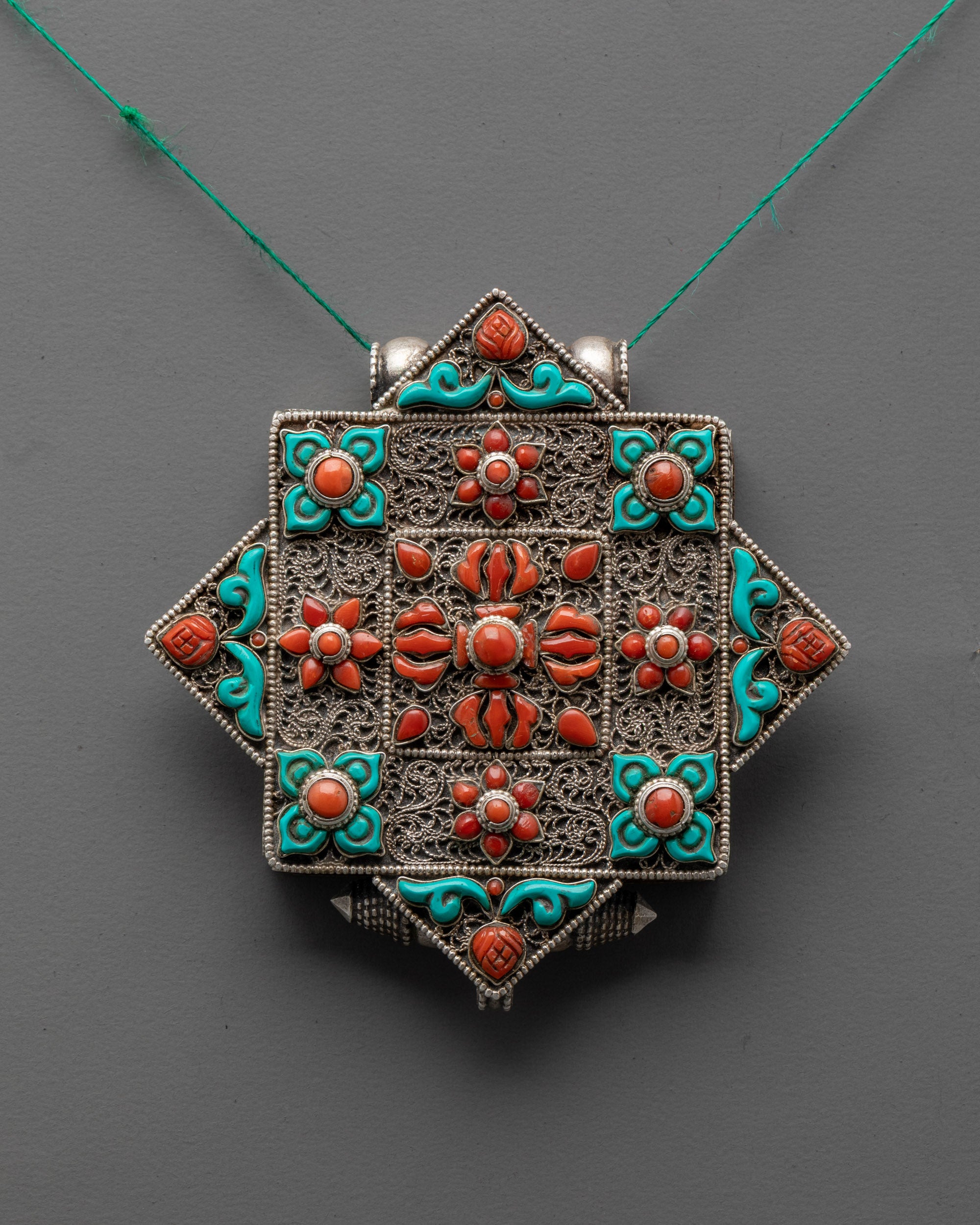 Handcrafted Bishwo Vajra Locket front view with silver, coral double vajra, and turquoise detail