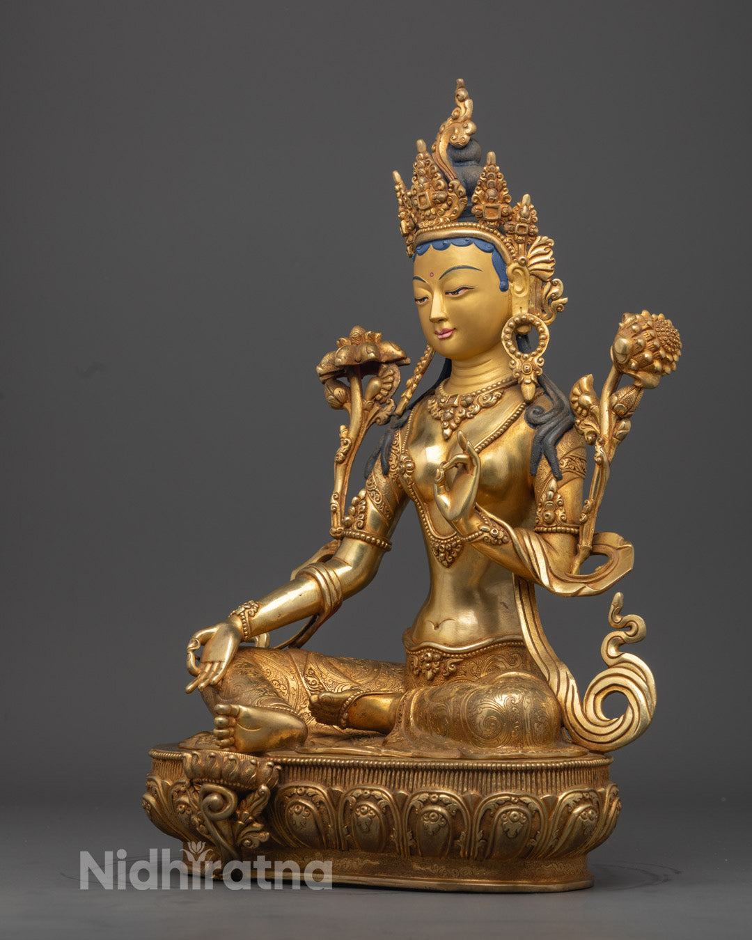 Handcrafted Green Tara statue holding blue utpala flower, symbolizing purity and spiritual awakening