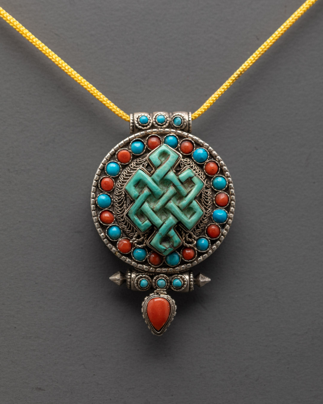 Handcrafted Infinity Knot Locket with silver filigree design and colorful semi-precious stones