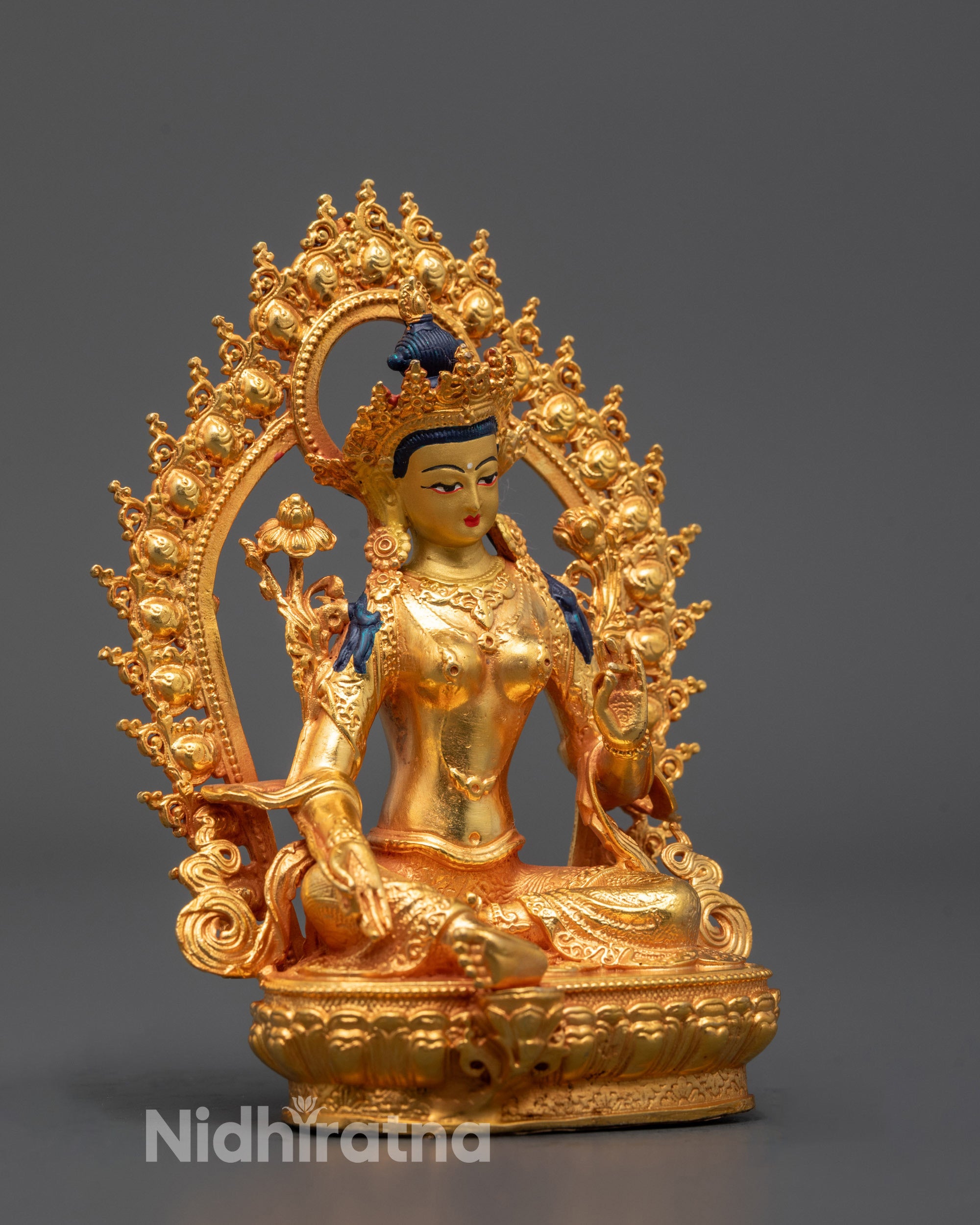 Handcrafted Nepalese Green Tara statue with golden halo sitting gracefully on lotus base