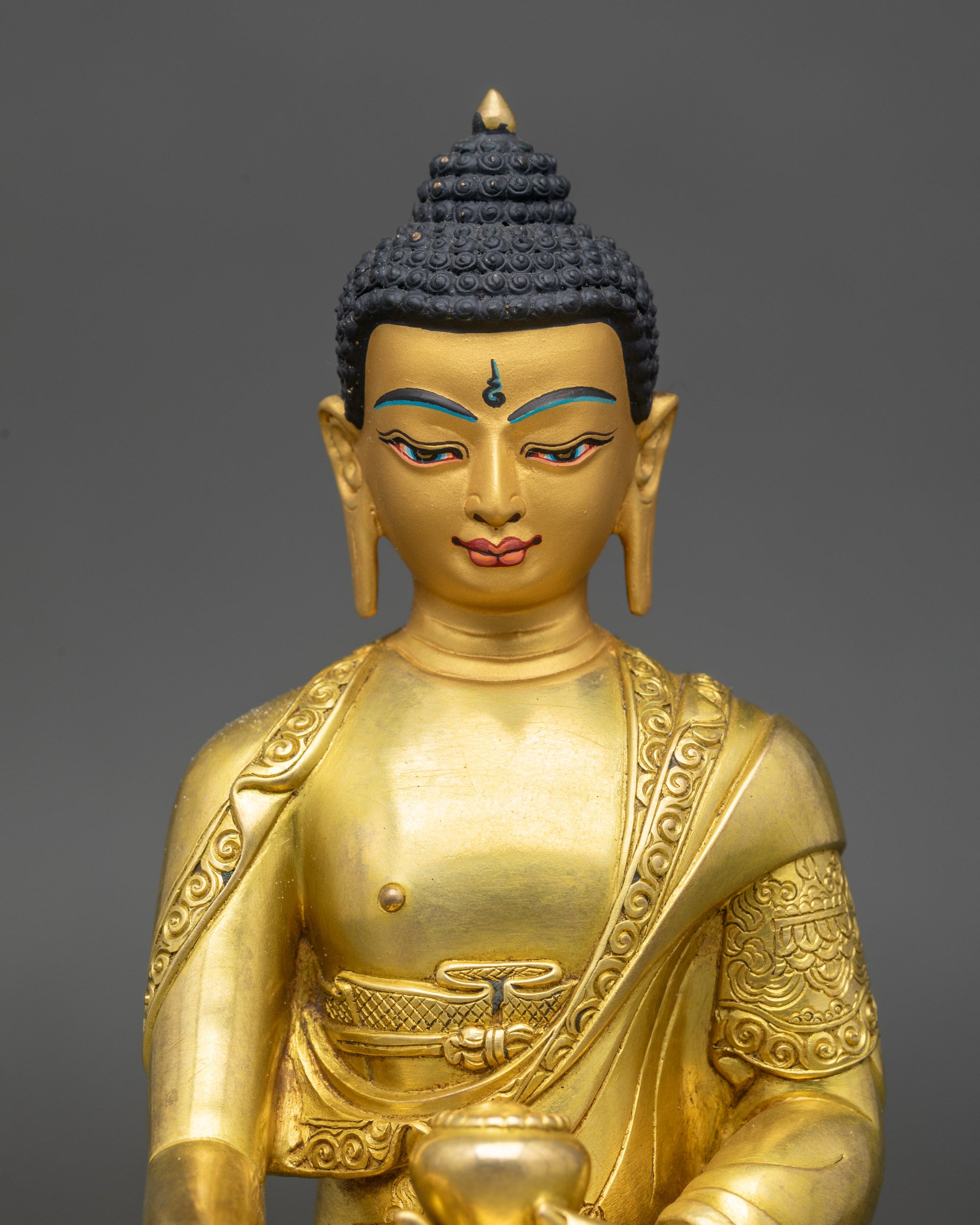 Handcrafted Shakya Thubpa sculpture by Newari artisans featuring serene gold-painted face and intricate robes