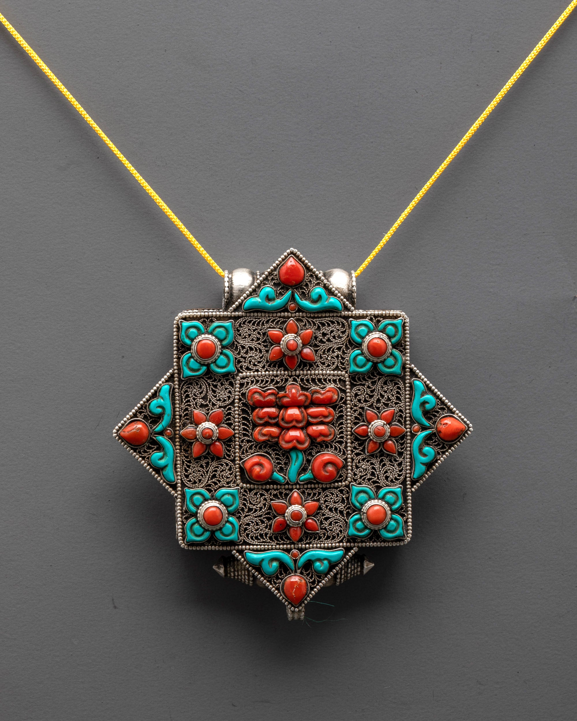Handcrafted Tibetan Flower Amulet Locket front view with silver body and coral turquoise stones