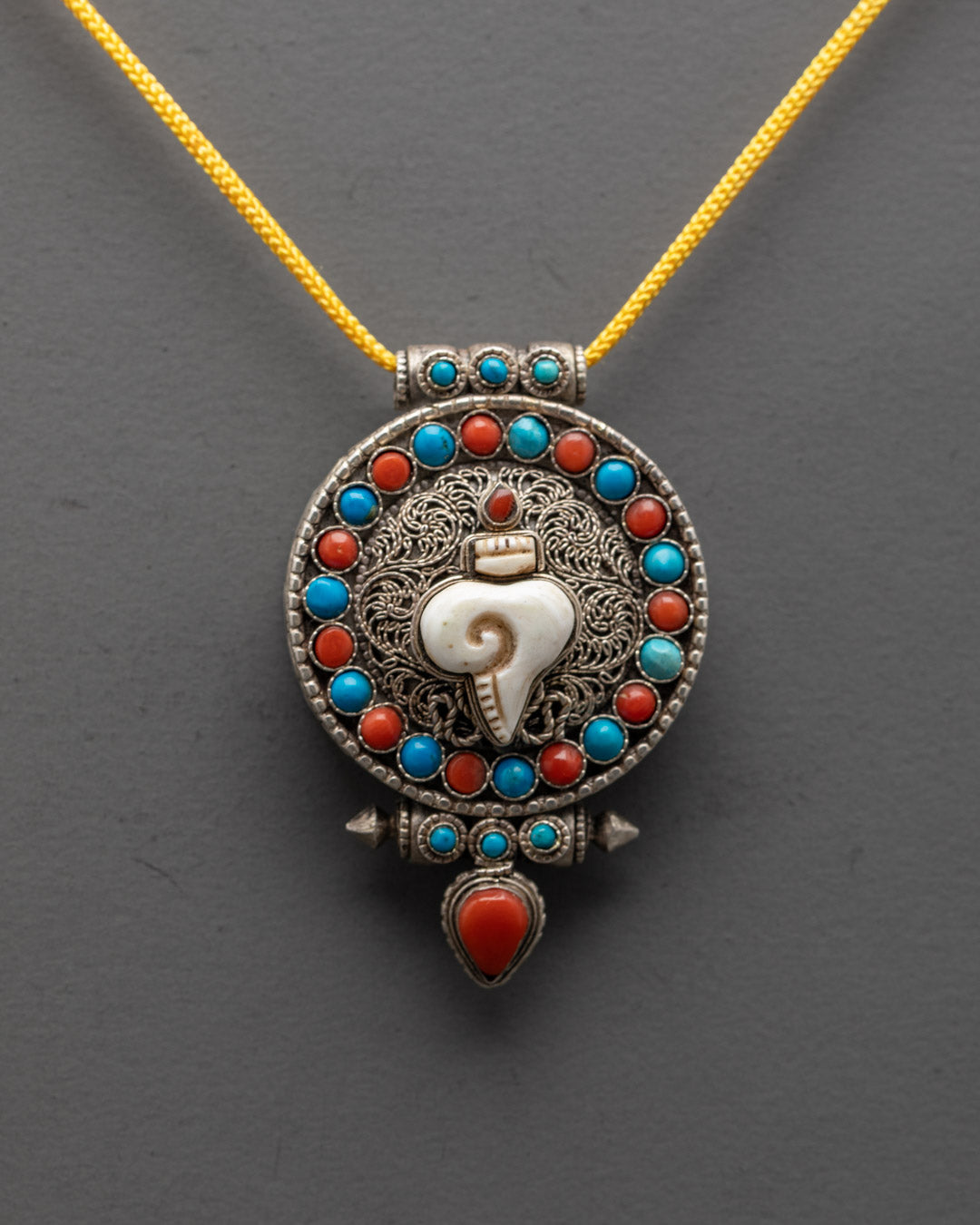 Handcrafted silver shell locket with intricate filigree design and colorful semi-precious stones