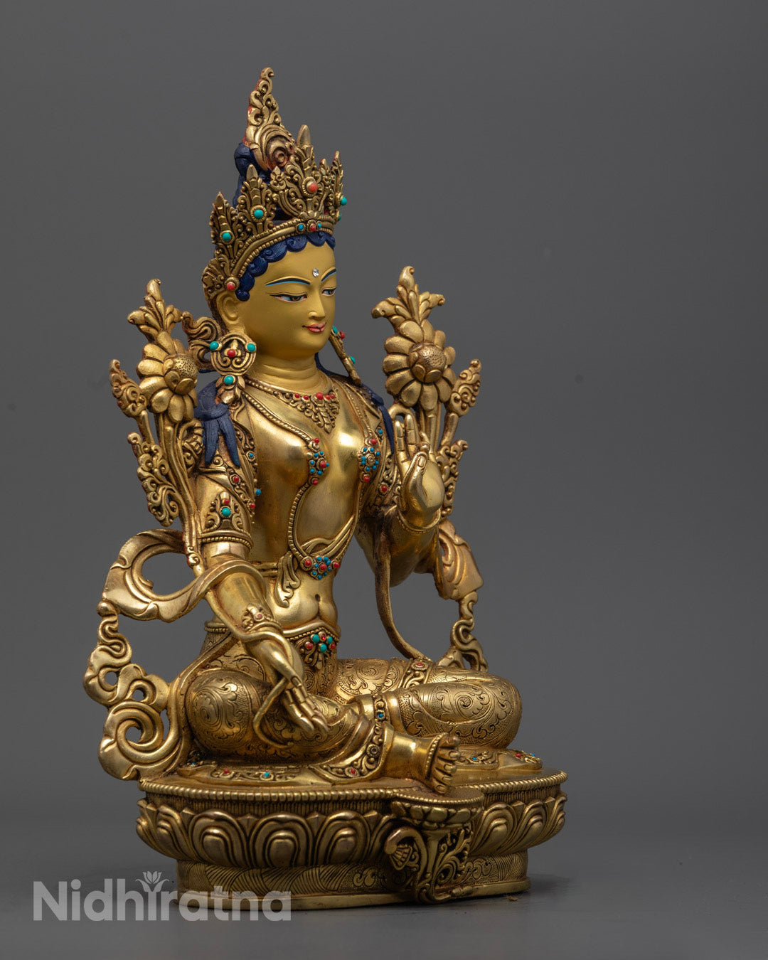 A serene, seated Green Tara statue with one leg raised, representing protection and compassion in Tibetan Buddhism.