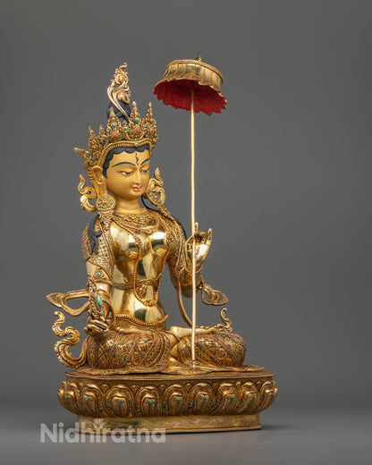 Intricate crown and jewelry of the White Umbrella Deity statue decorated with vibrant acrylic colors and gemstones