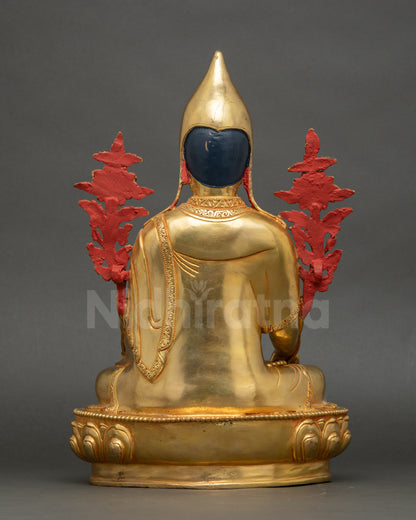 Intricately carved Longchenpa monk robe with floral motifs on gold-fire gilded Himalayan statue