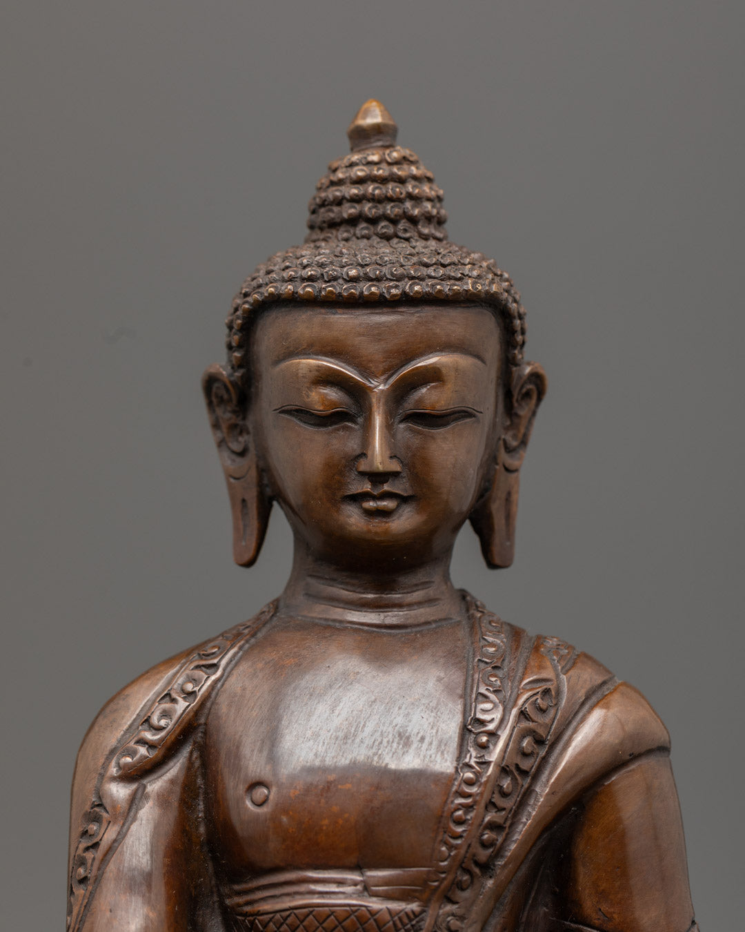 Intricately detailed Amitabha Buddha statue made using the lost wax method, featuring oxidized copper and gold gilded face, painted with acrylic colors.