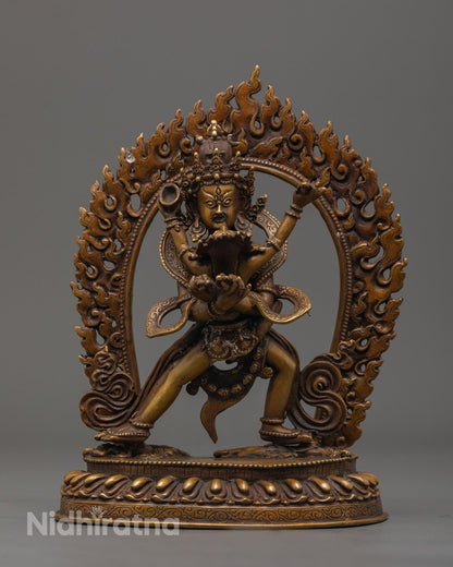 Intricately detailed Chakrasamvara statue standing on a sun disc with fiery aura, crafted from oxidized copper.