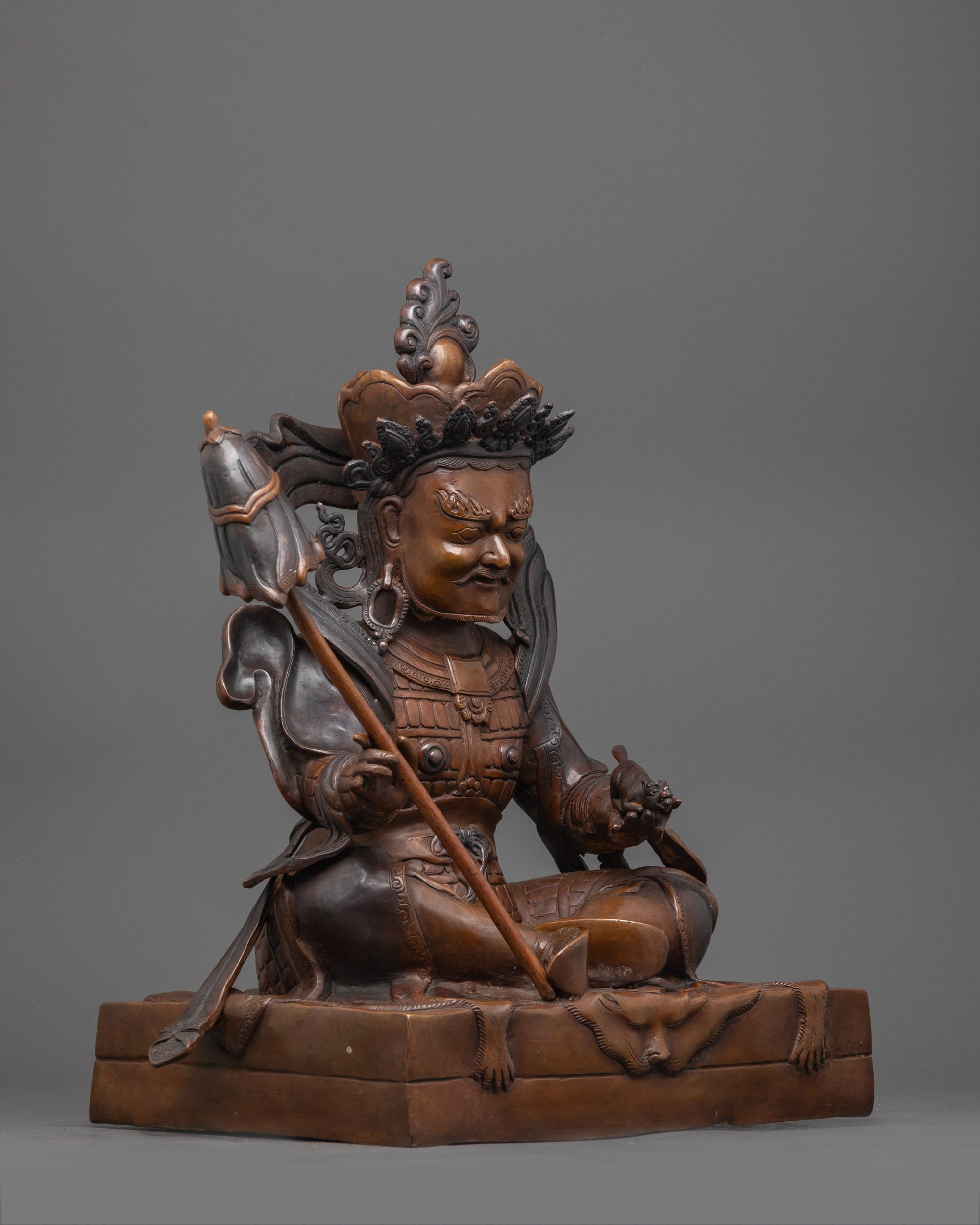 Intricately detailed Virupaksa figure made from oxidized copper, seated on a plain base