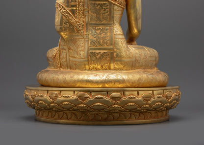 Landscape back shot of Buddha statue seated on lotus base showing robe details
