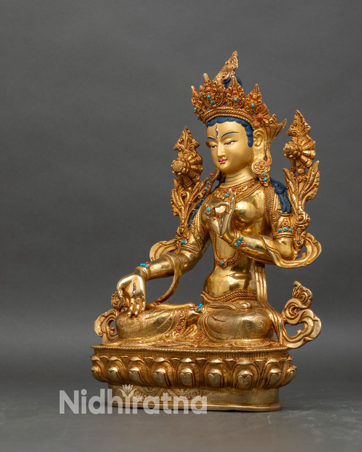 Left profile of White Tara sculpture, gold-gilded copper with lotus and utpala flower
