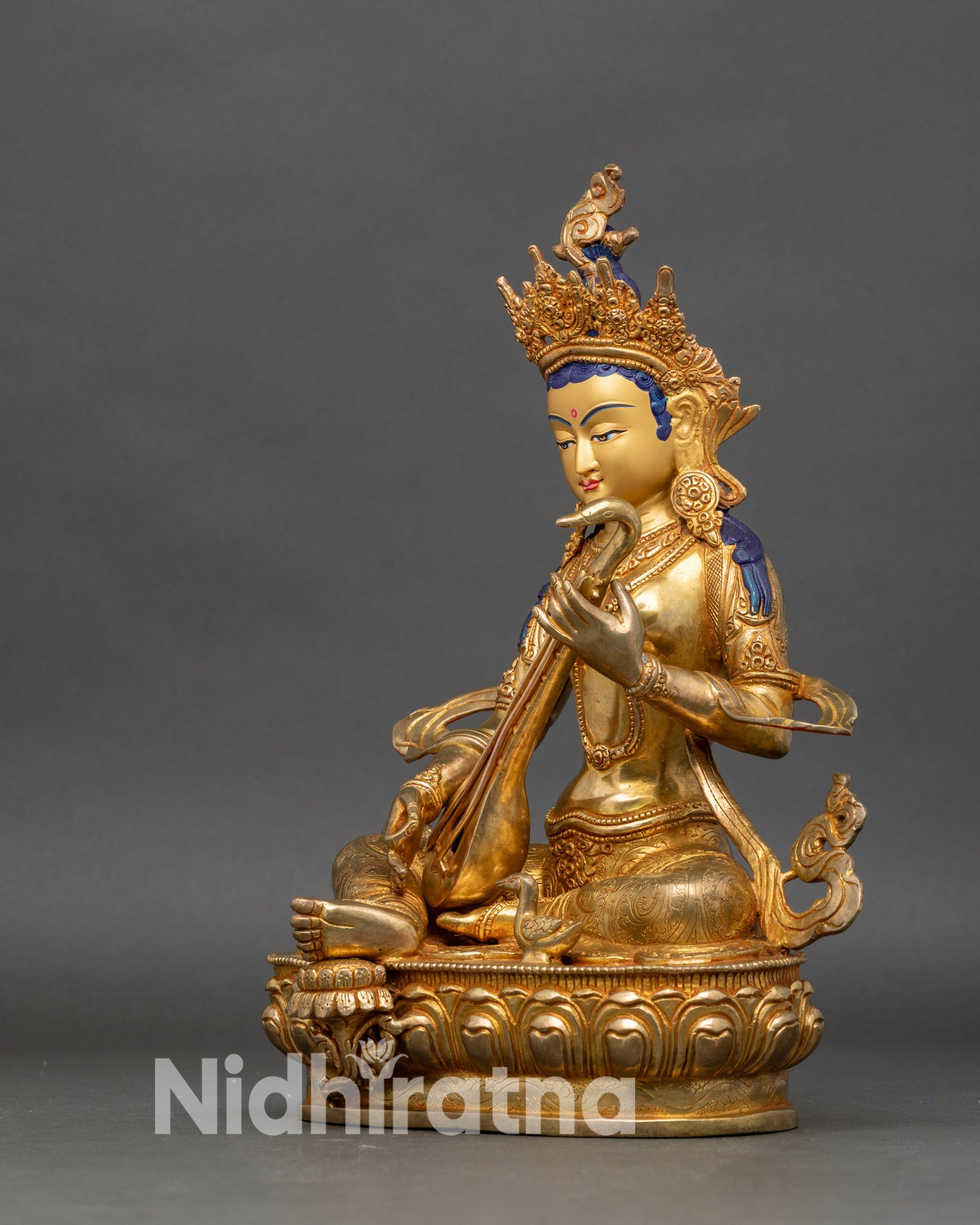 Left profile of Saraswati goddess statue with lotus base and intricate gold details