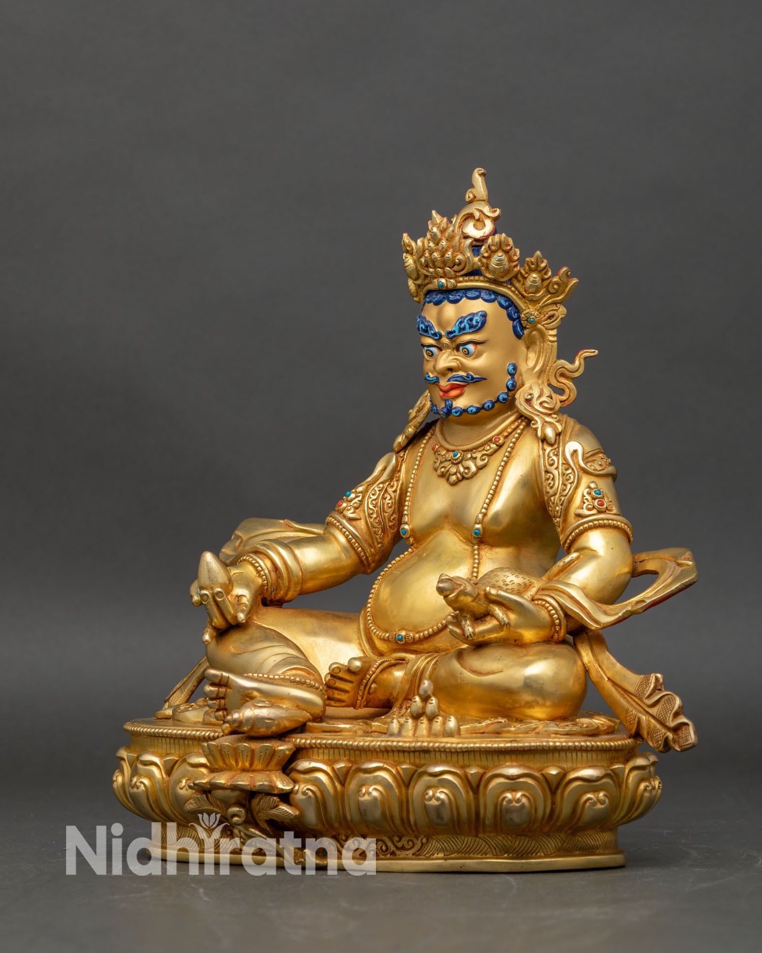 Left side view of Dzambhala statue, detailed gold gilding and traditional iconography