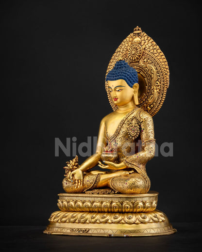 Left side view of Healing Buddha statue displaying monastic robe repoussé details and floral halo patterns