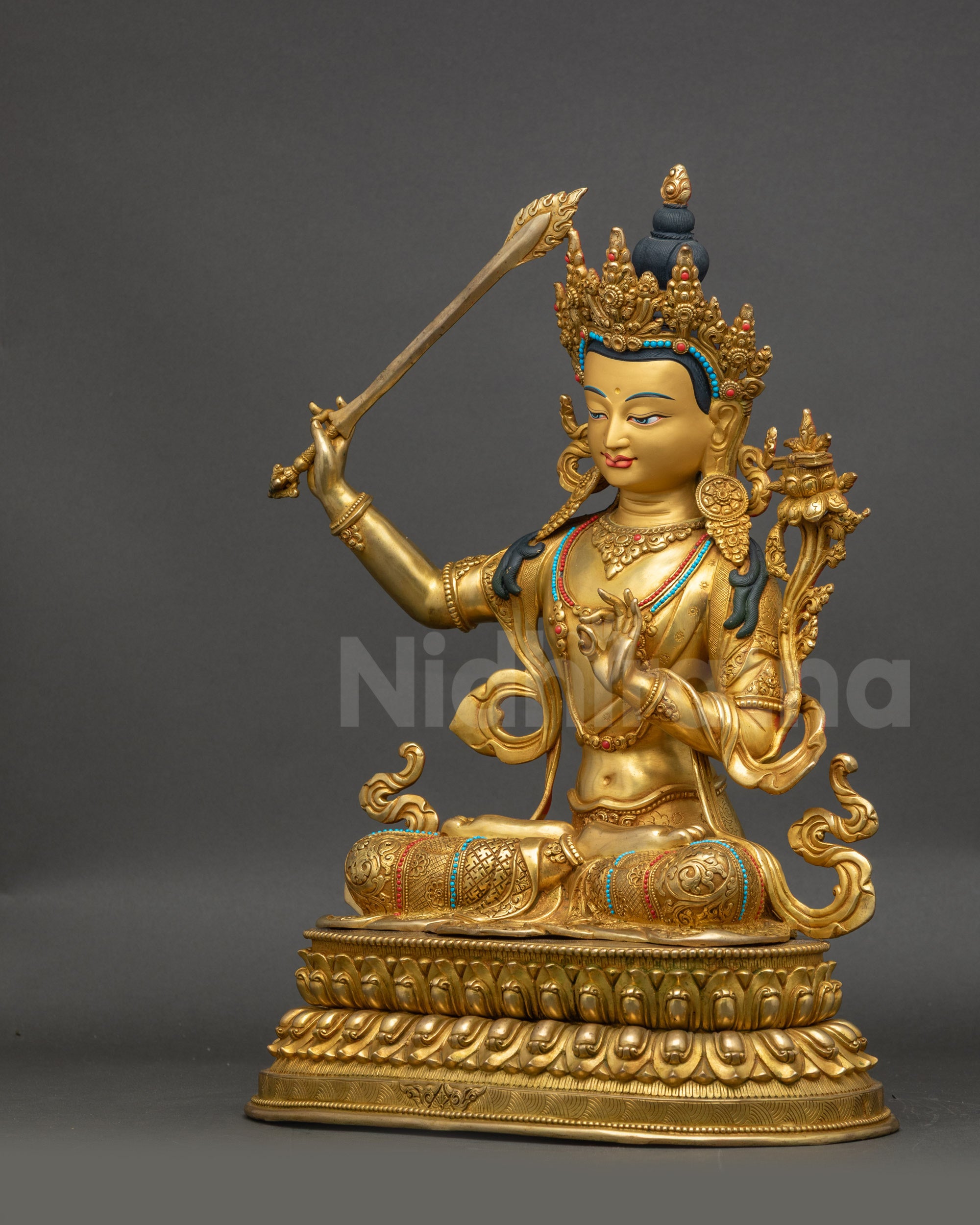 Left-side view of Manjushri statue highlighting Abhaya mudra and detailed crown