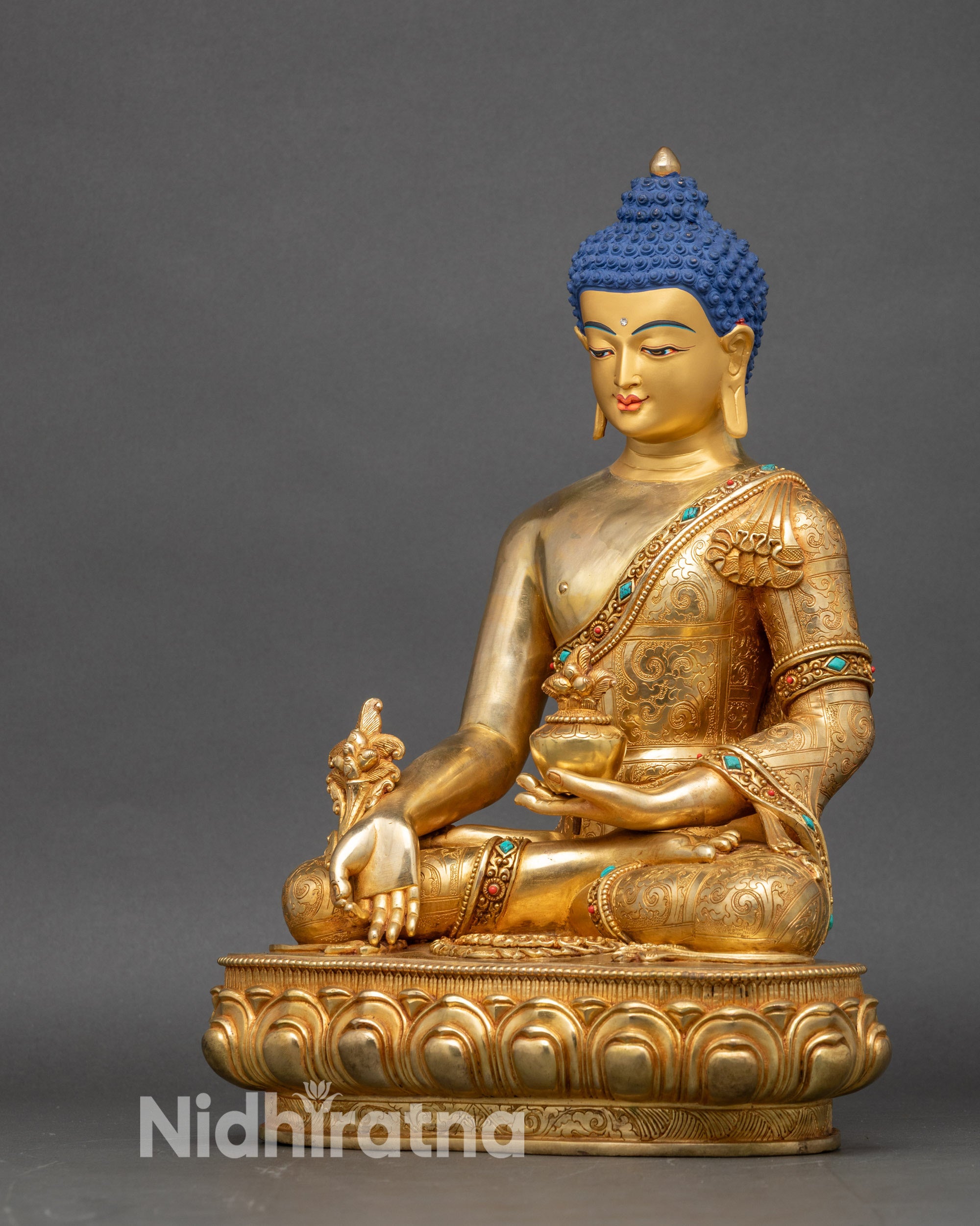 Left profile of Medicine Buddha statue, detailed kasaya robe and sacred healing bowl