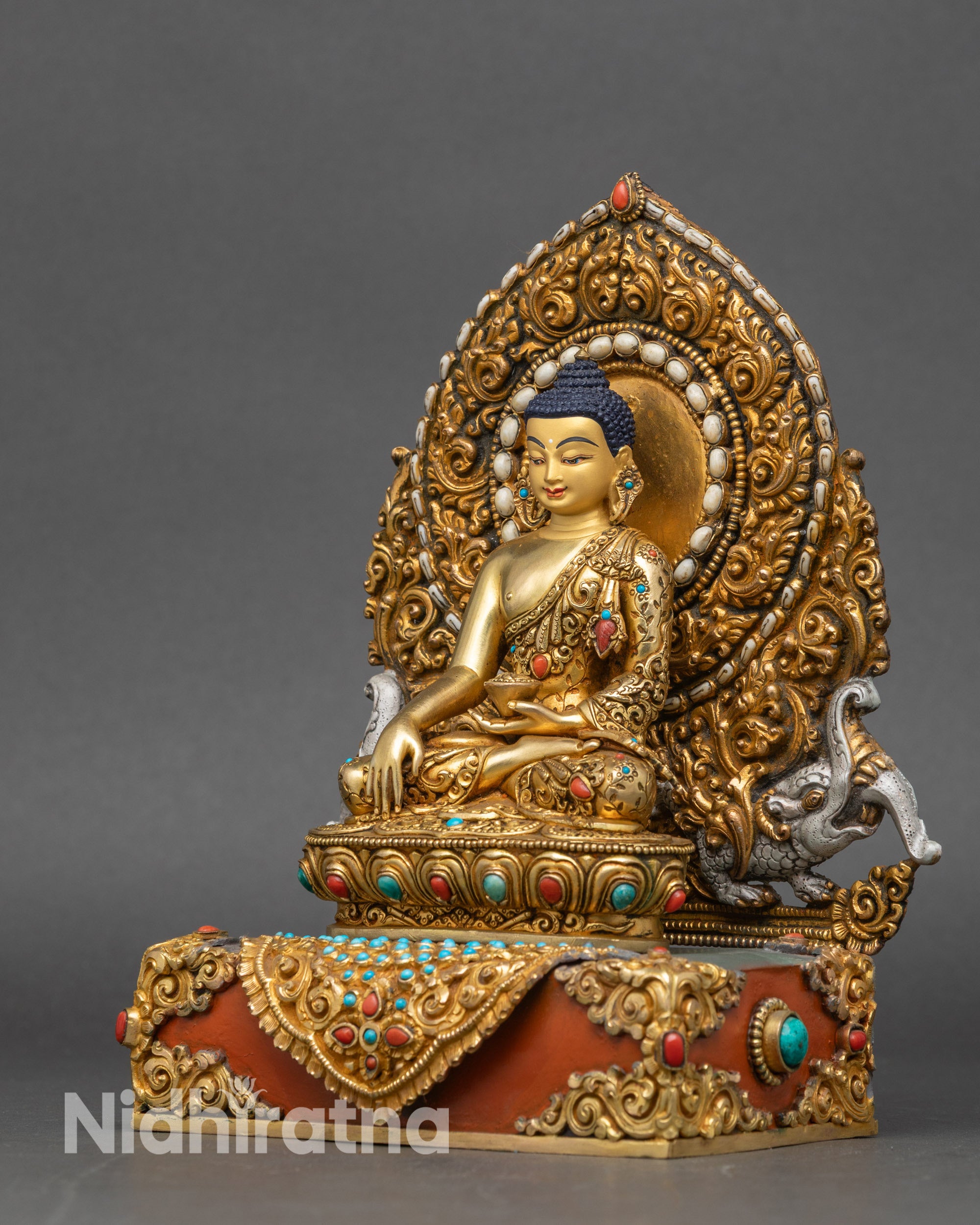 Left profile of gold-gilded Shakyamuni Buddha seated on lotus pedestal