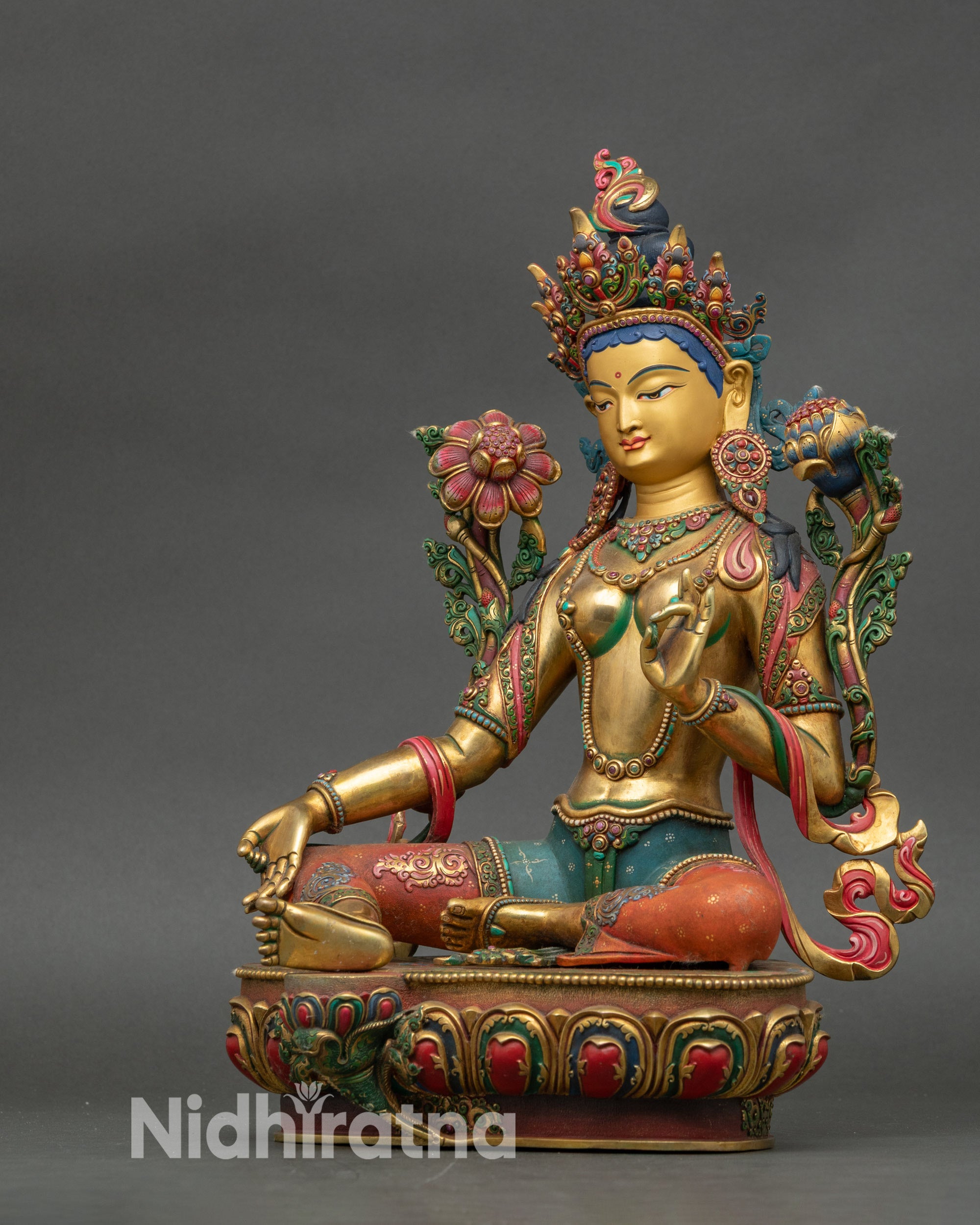 Left side detail of Green Tara statue with gold fire-gilding and floral robes