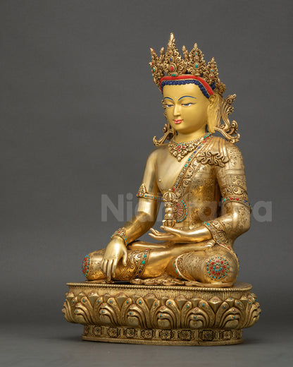 Left side of Mitrugpa Buddha statue highlighting meditation posture, Vajra, and gold-gilded details.