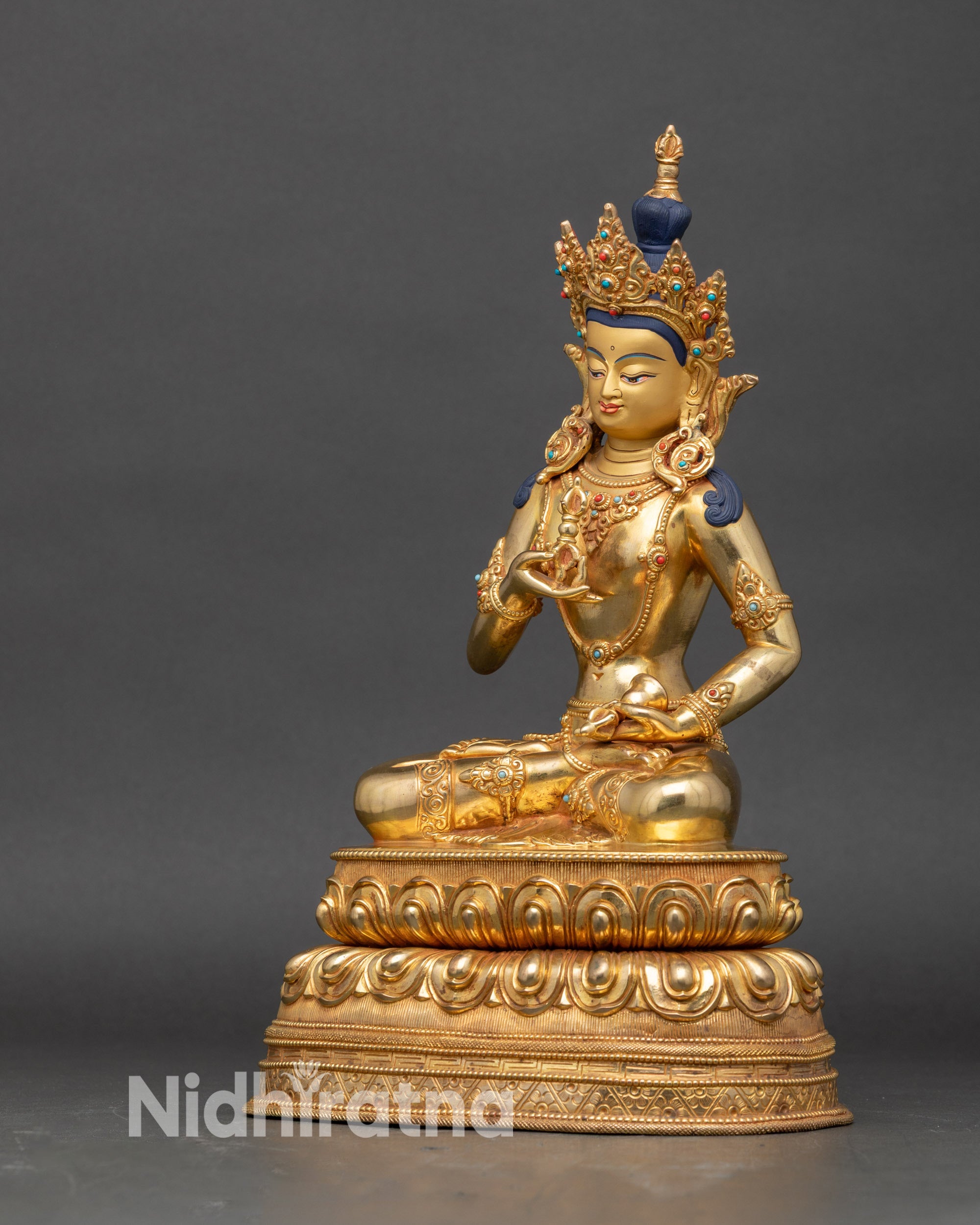 Left side of Vajrasattva statue showing bell and lotus pedestal details