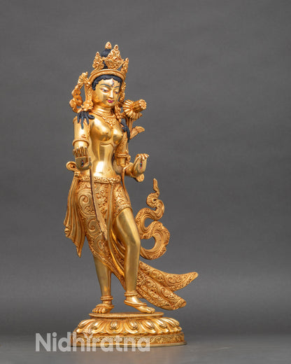 Left side of White Tara sculpture, holding utpala lotus, intricate garments