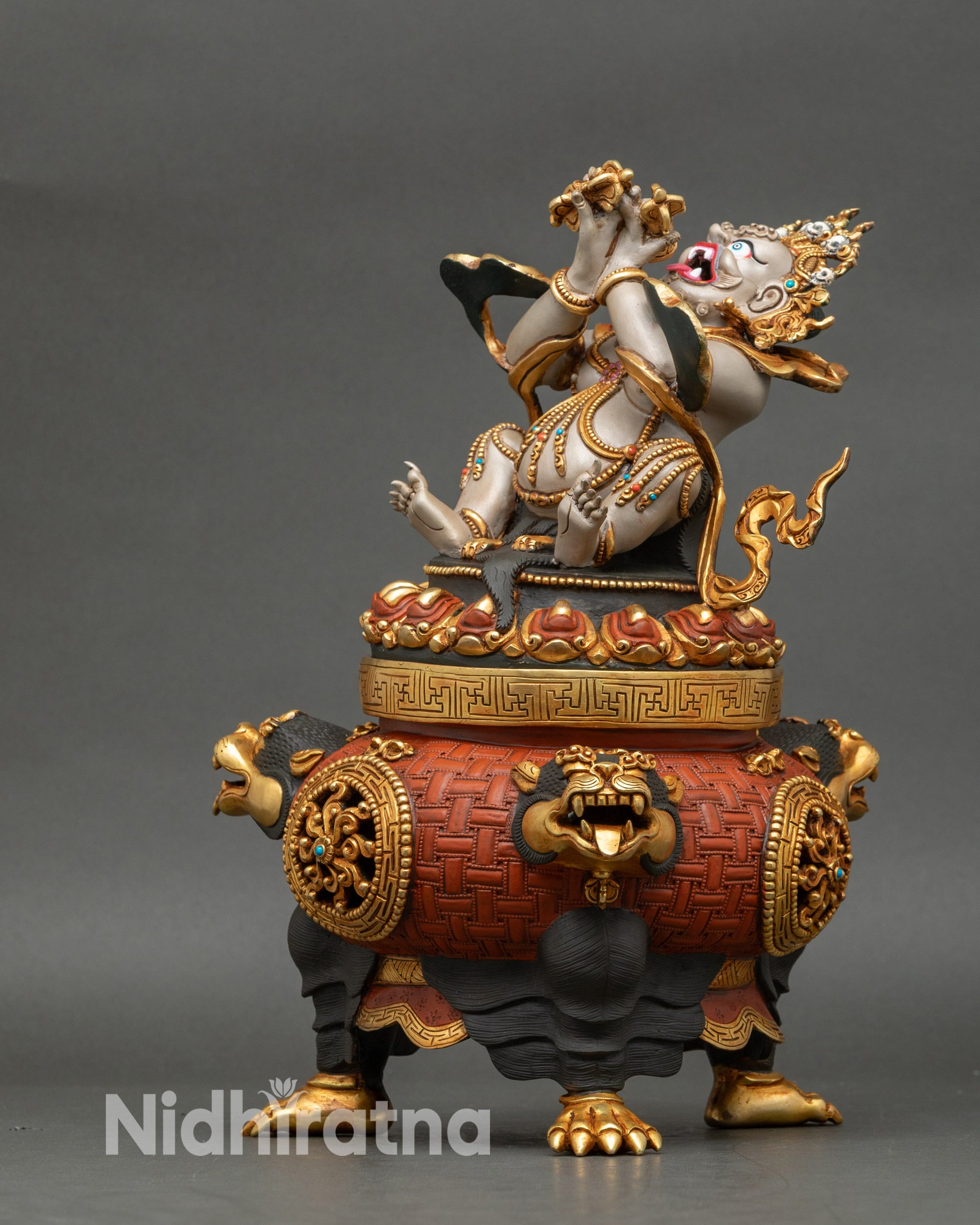 Left side profile of Vajradhaka statue with detailed gold gilded robes