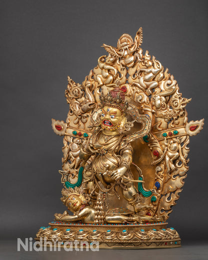 Left side view of Black Dzambhala statue, detailed gold-gilded tantric deity with serpent motif