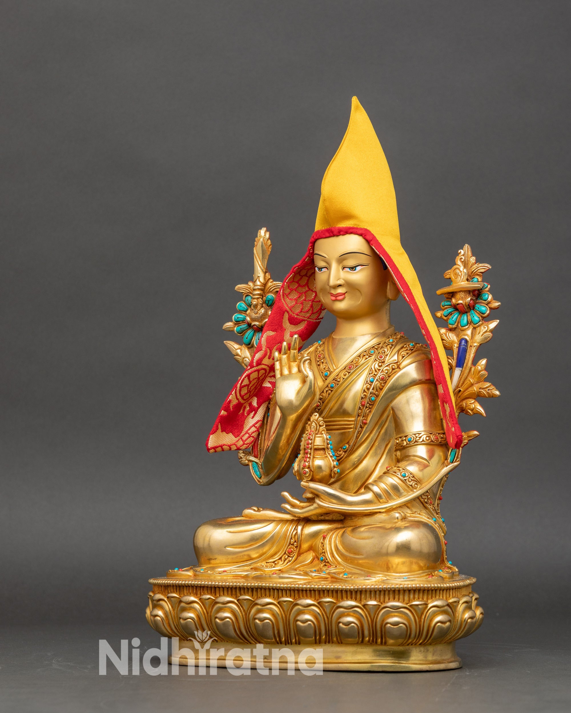 Left side view of Je Tsongkhapa statue, seated on lotus pedestal with iconic pandita hat and detailed robes