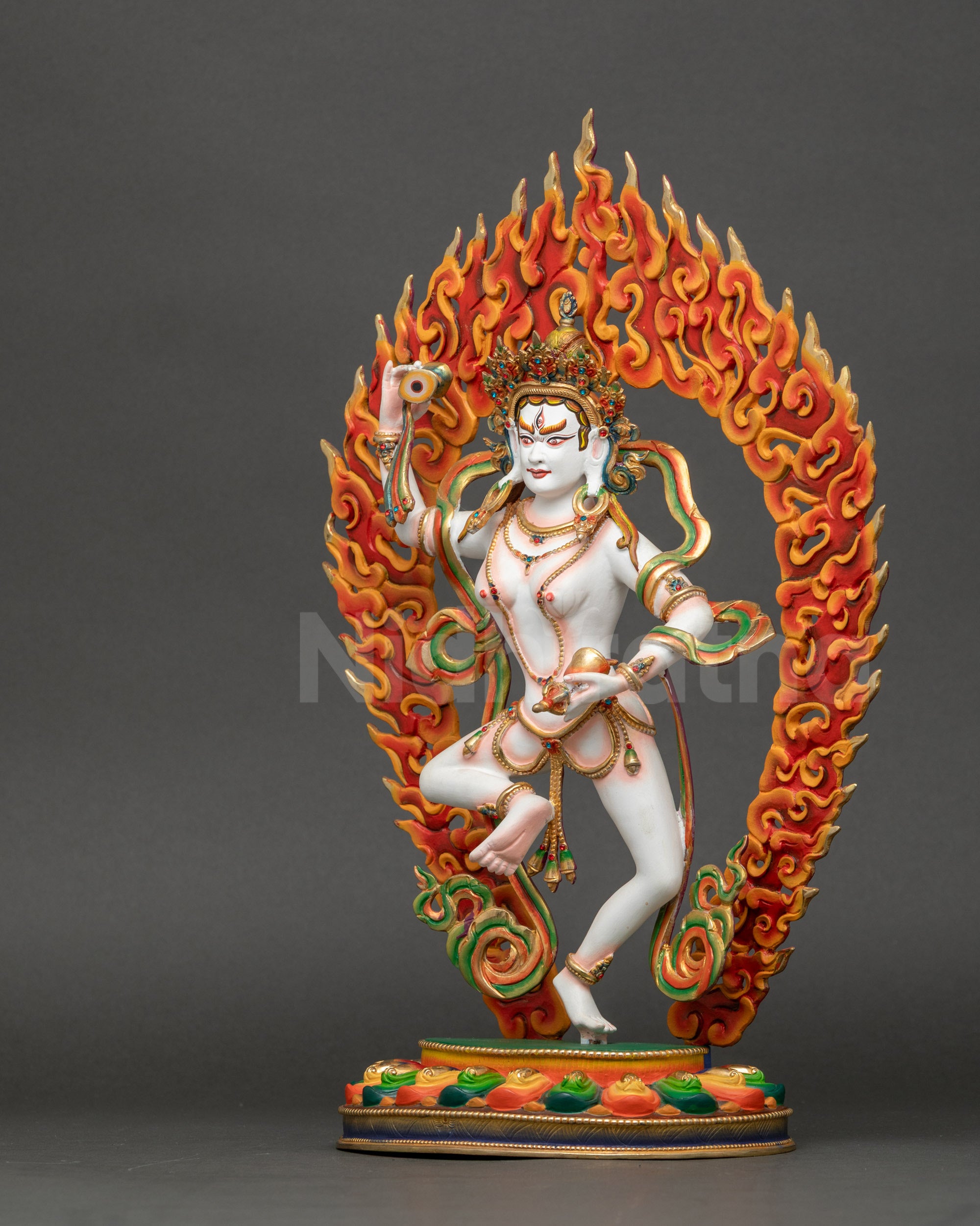 Left side view of Machig Labdrön Statue displaying bell and hand drum details