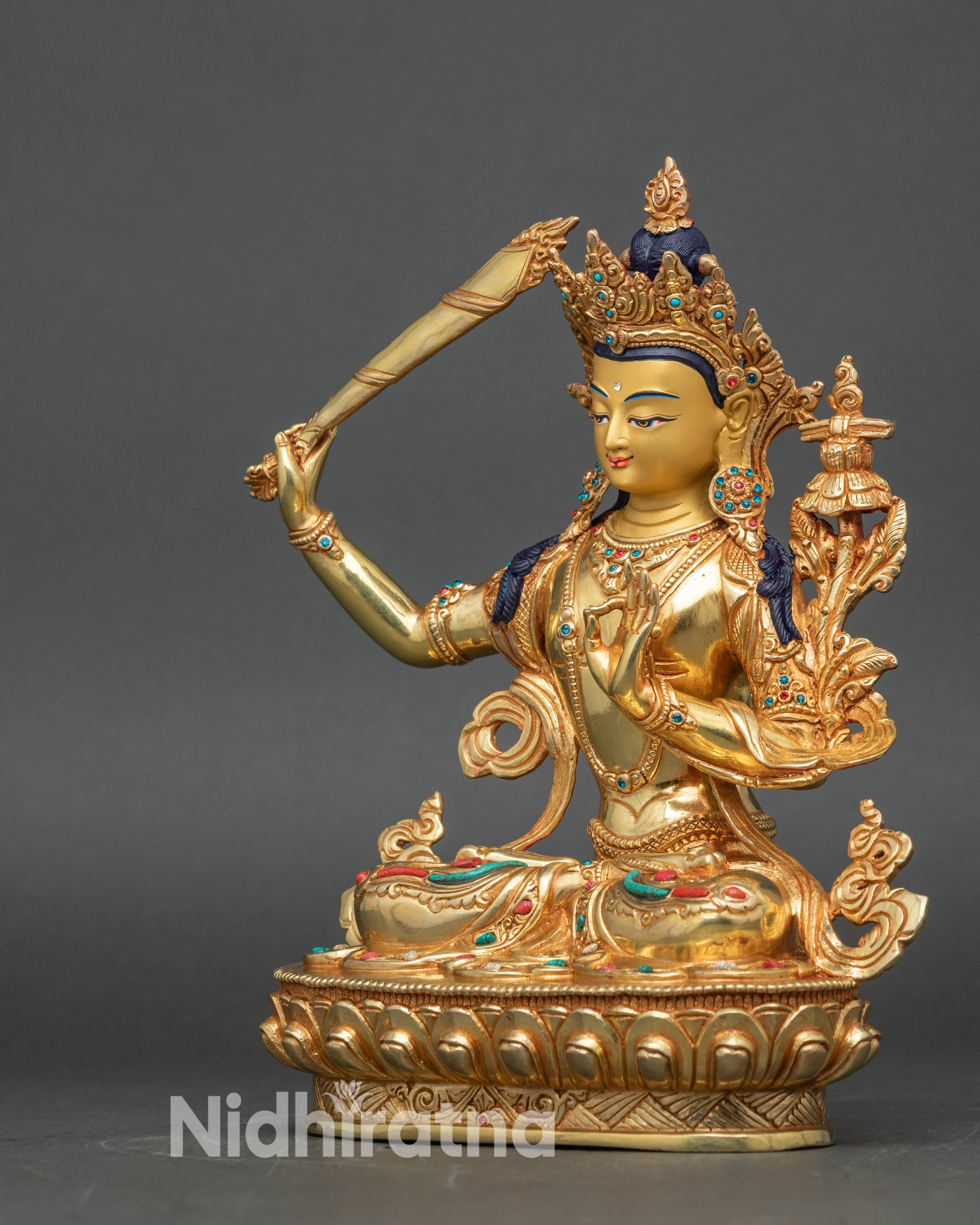 Left side view of Manjushri statue, showcasing detailed patterns and sacred Buddhist symbolism
