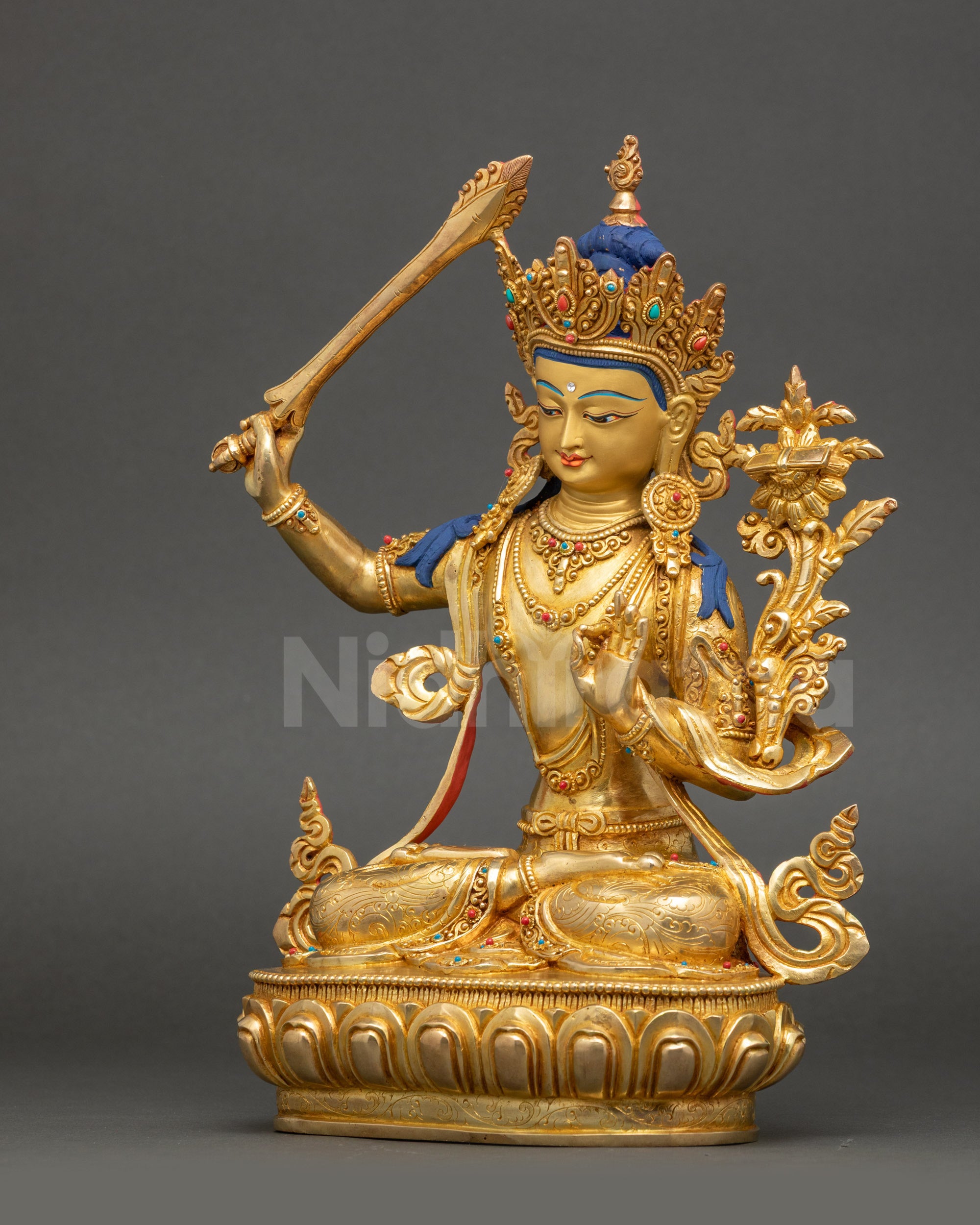 Left side view of Manjushri statue with detailed swirling garments
