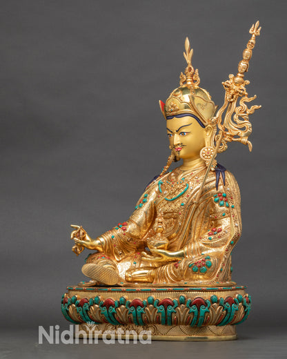 Left side view of Padmasambhava statue, gold fire-gilded copper with ornate robes and crown