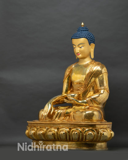 Left side view of Shakyamuni Buddha statue revealing alms bowl, draped robes and lotus throne carvings