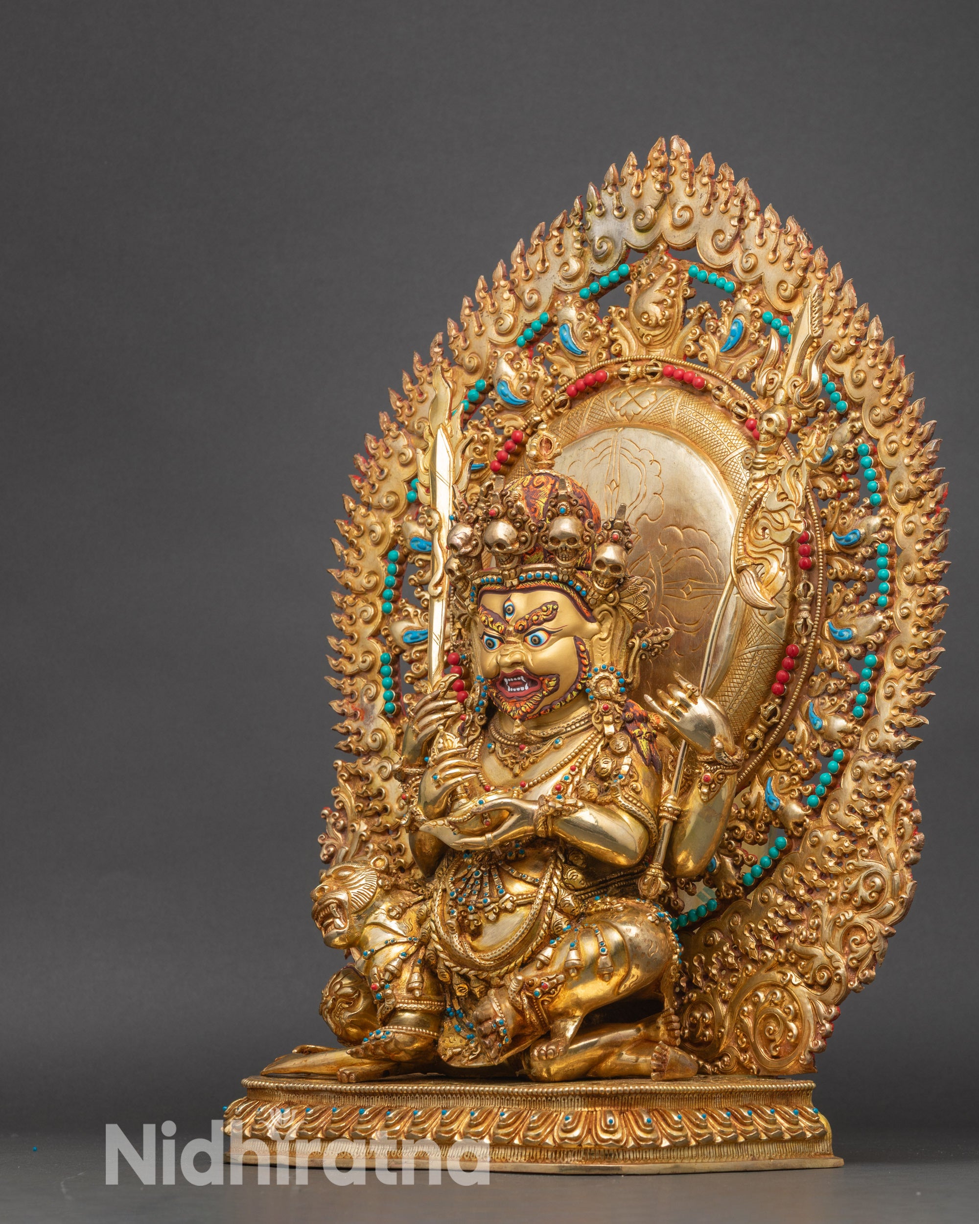 Left view Chaturbhuja Mahakala statue with dynamic robes and flame halo.