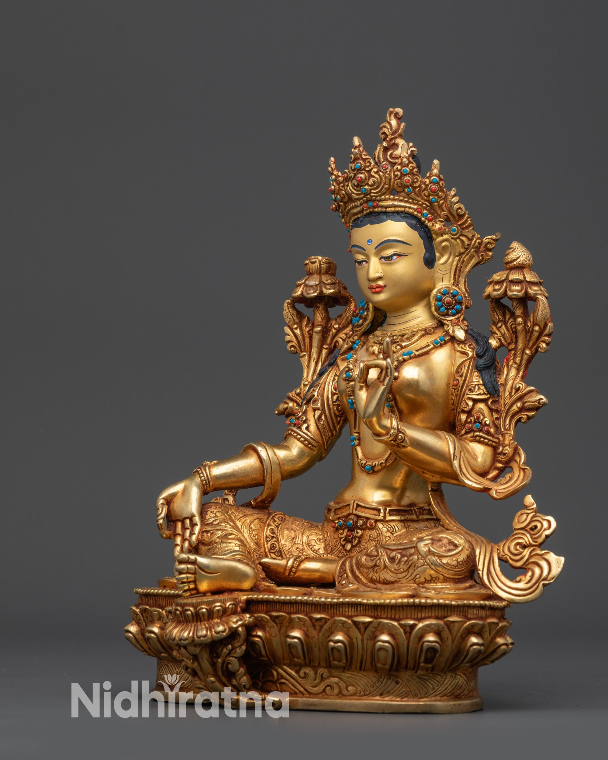 Left view side Green Tara holding Utpala flower with robe and jewelry carvings visible