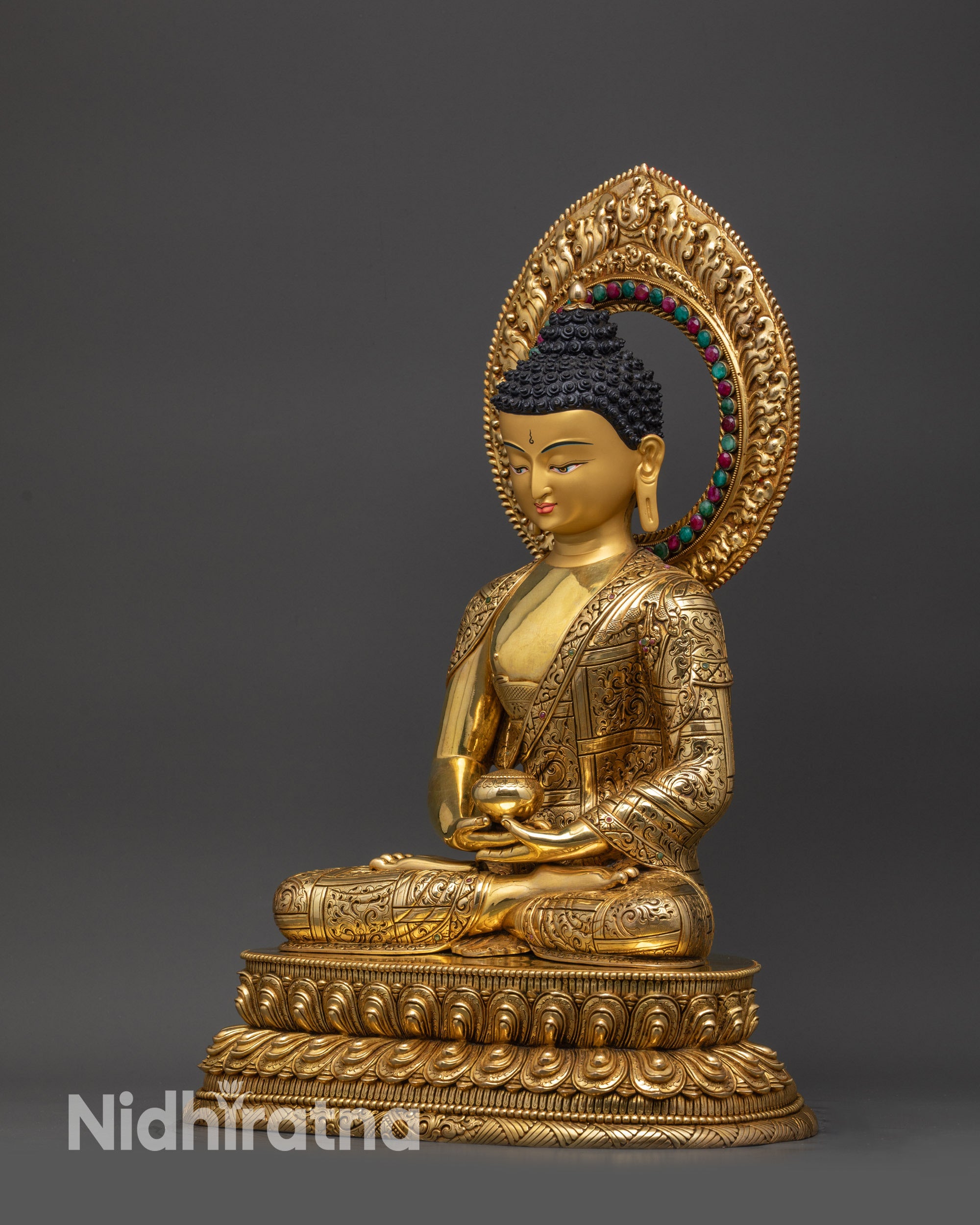 Left view side of Amitabha Buddha showing gold-gilded robes and semi-precious halo
