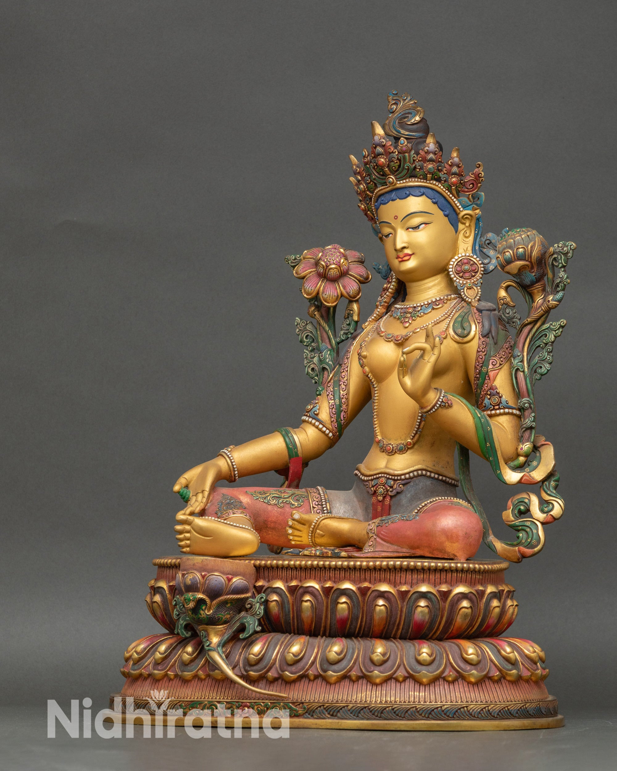Left view side of Green Tara sculpture highlighting yellow body and sacred mudras
