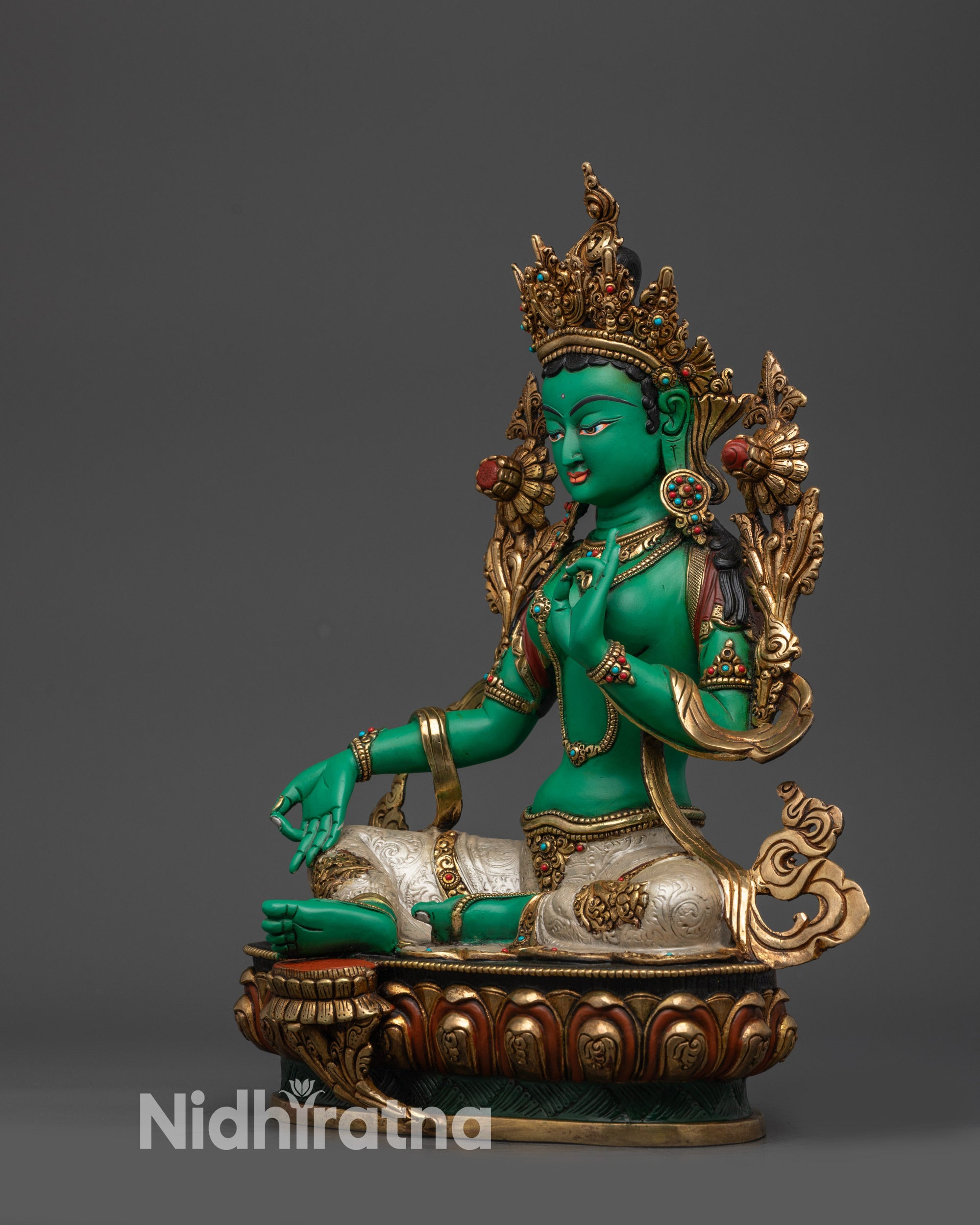 Left view side of Green Tara statue highlighting silver-plated lower garment