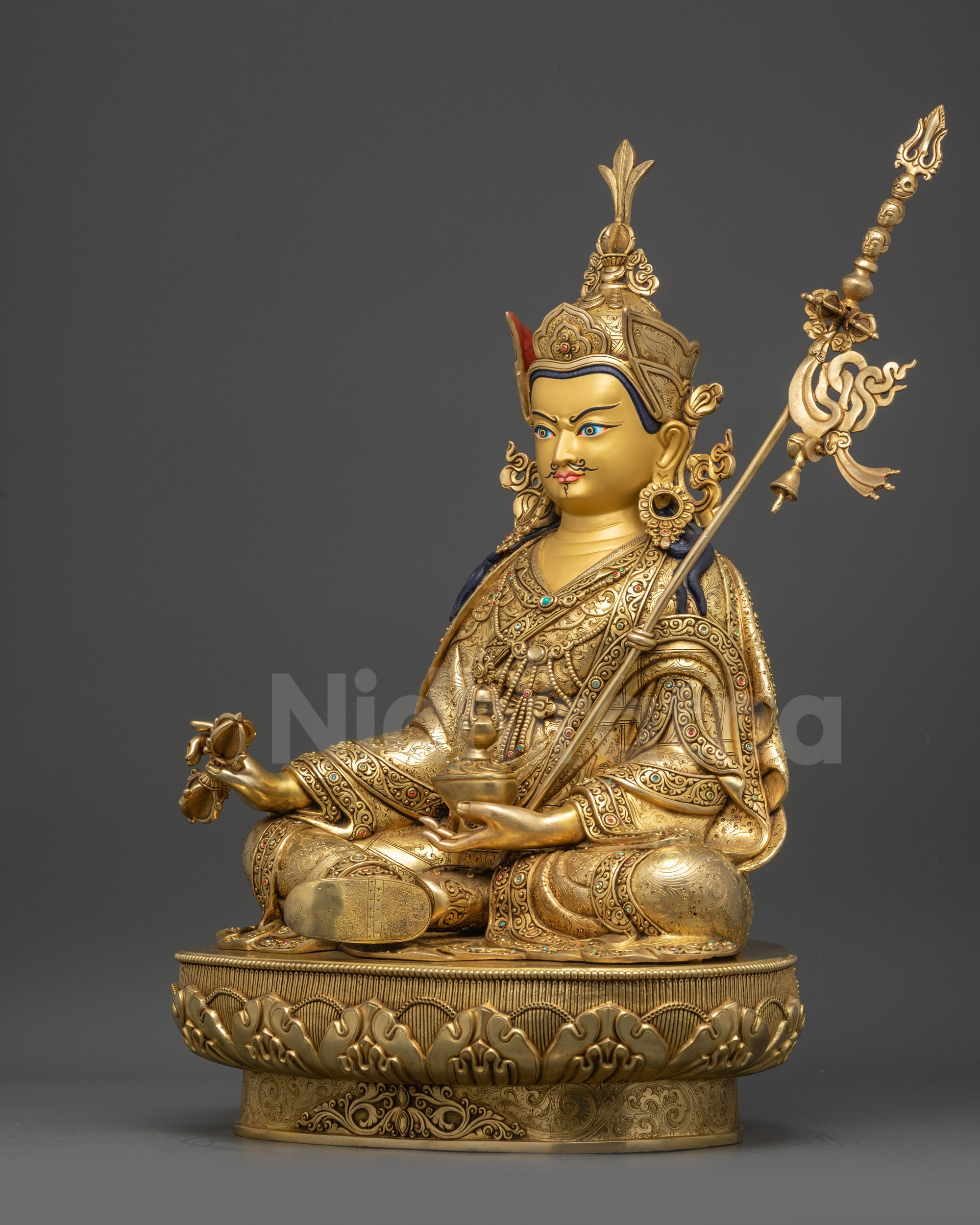 Left view side of Guru Rinpoche sculpture showing crown, robes, and lotus seat
