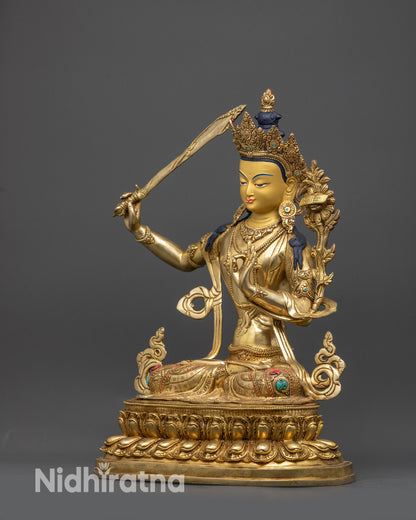Left view side of Manjushri sculpture highlighting gold-gilded robes and sacred symbols
