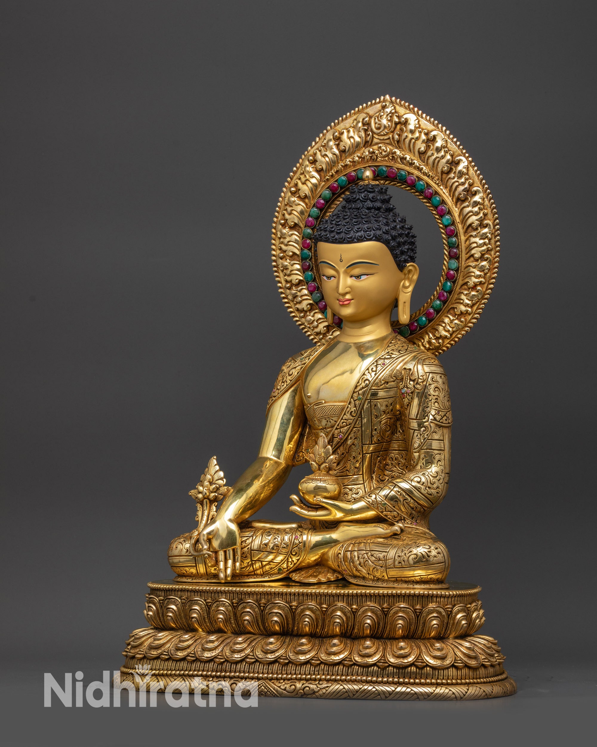 Left view side of Medicine Buddha statue showing lotus base and gold-gilded robes
