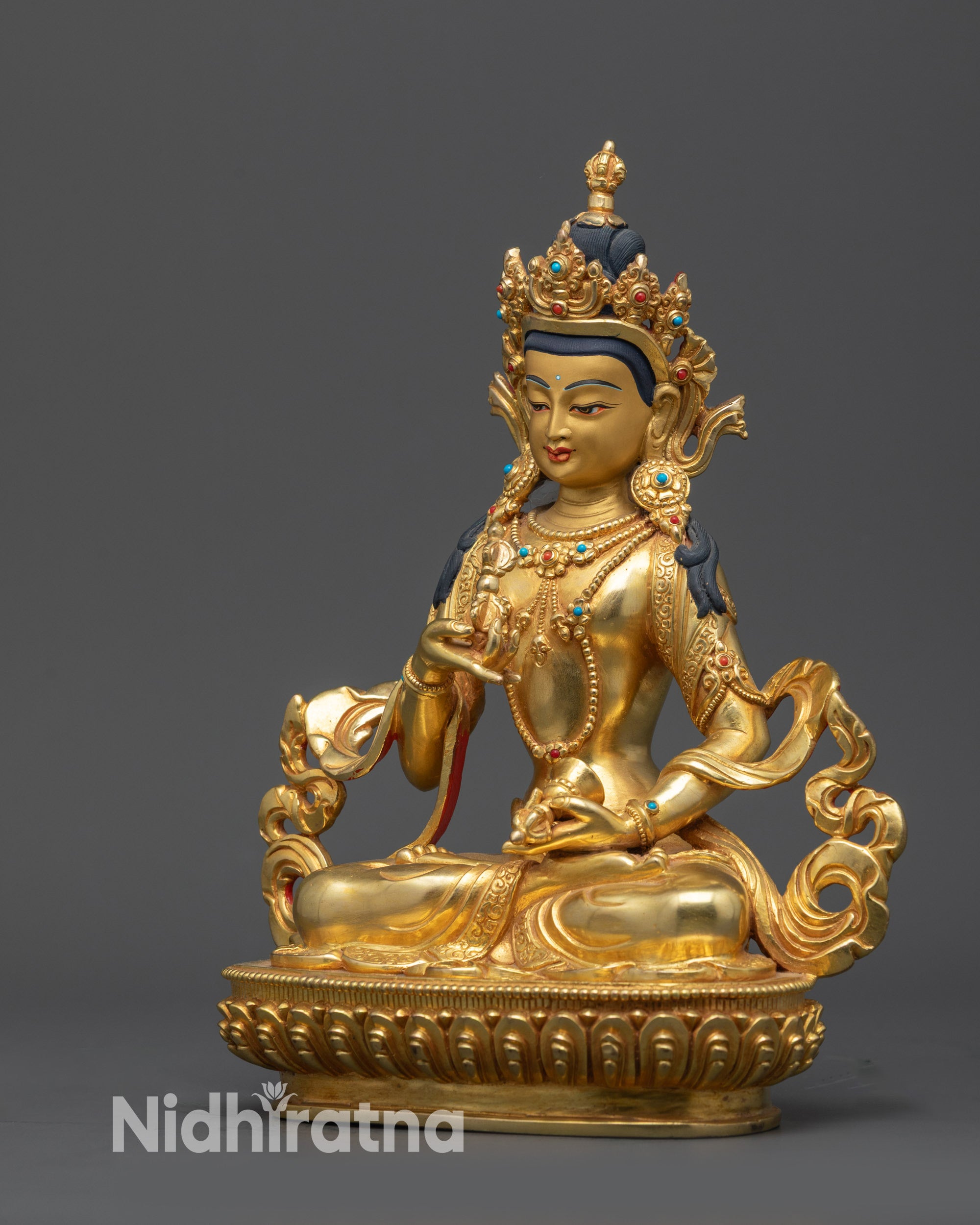 Left view side of Vajrasattva statue with vajra, bell, and flowing robe details
