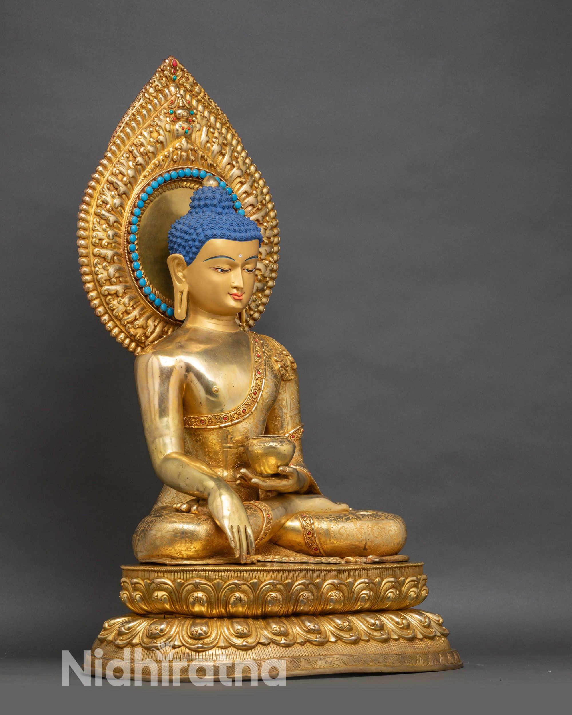 Life-size Buddha sculpture with earth-touching mudra hand gesture, begging bowl, and gilded robes
