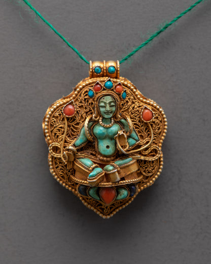 Close-up of intricate gold filigree and semi-precious stones on Green Tara locket pendant