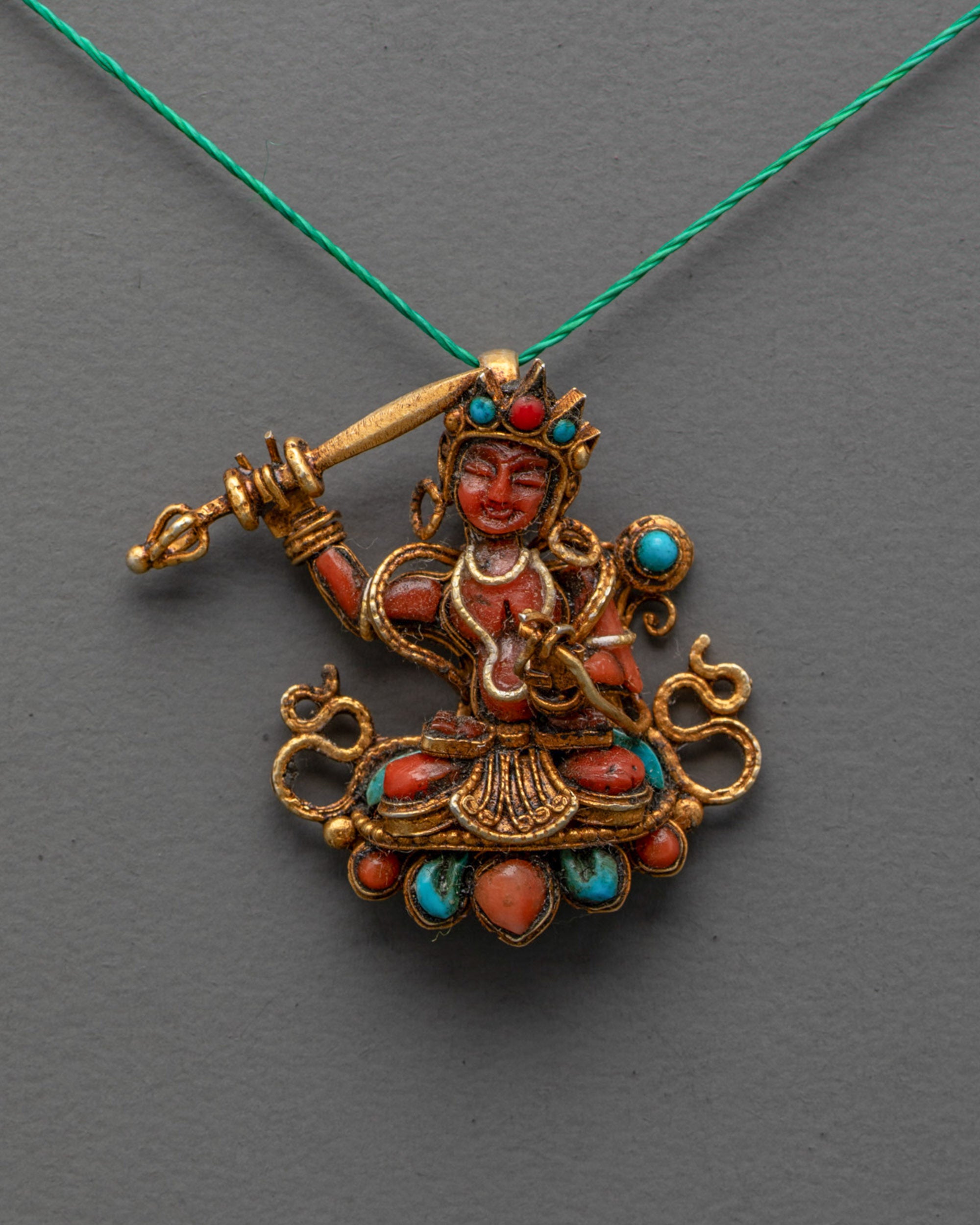 Front view of Coral Manjushri Locket with gold-gilded sword and gemstone inlay